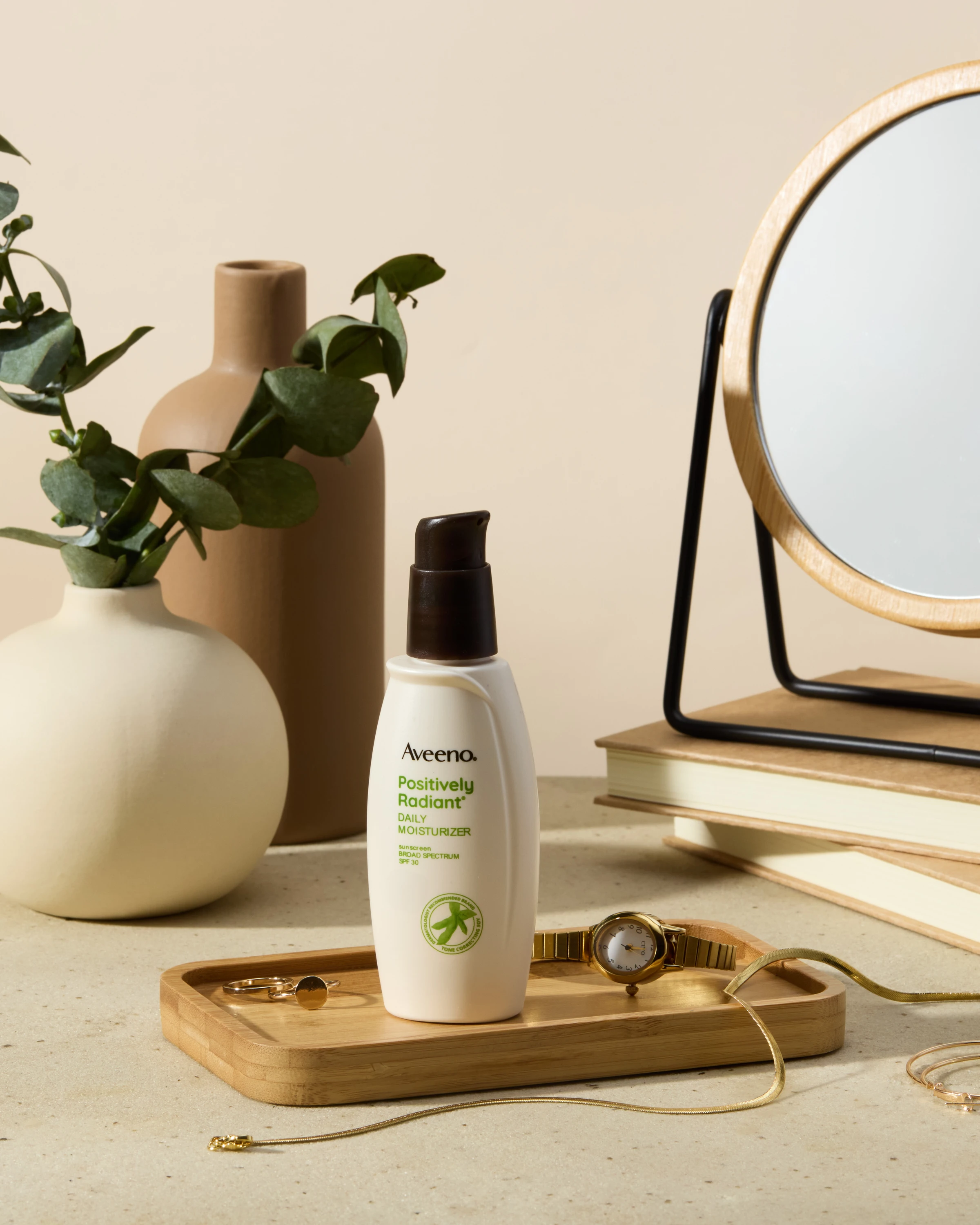 An Aveeno spray bottle on a dressing table beside a mirror.