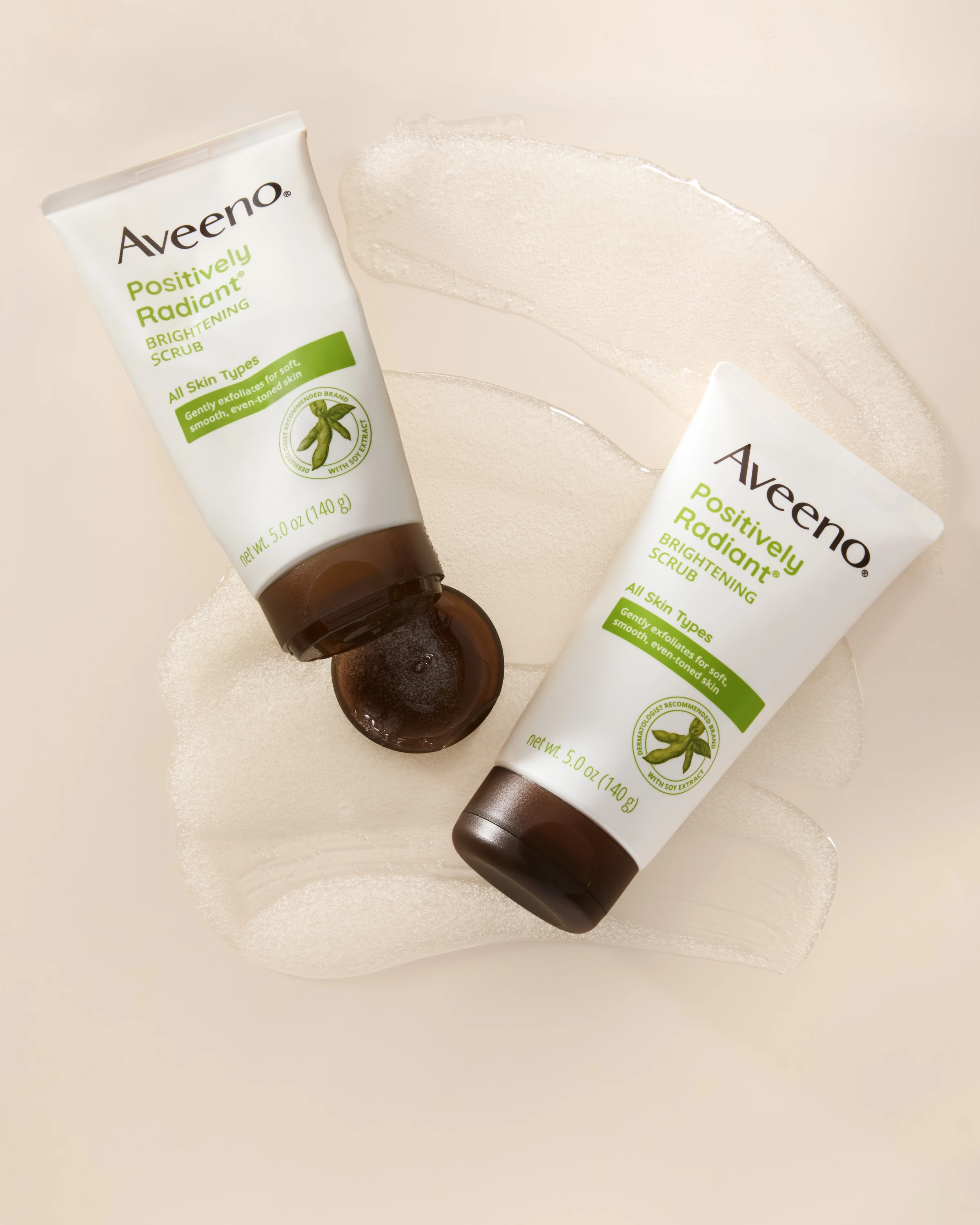 Two Aveeno product tubes arranged on a pale surface.