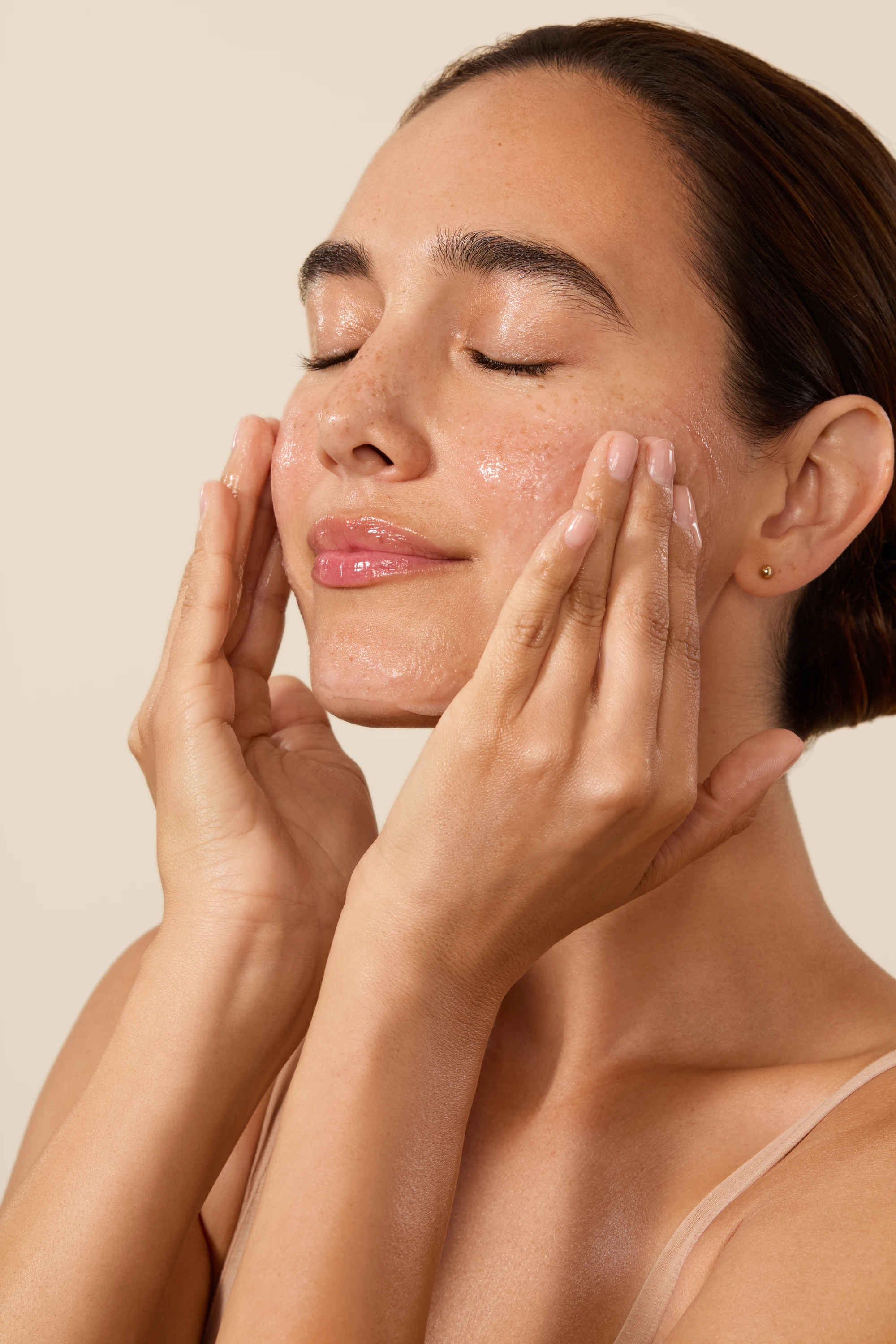 A model massaging product into her cheeks.
