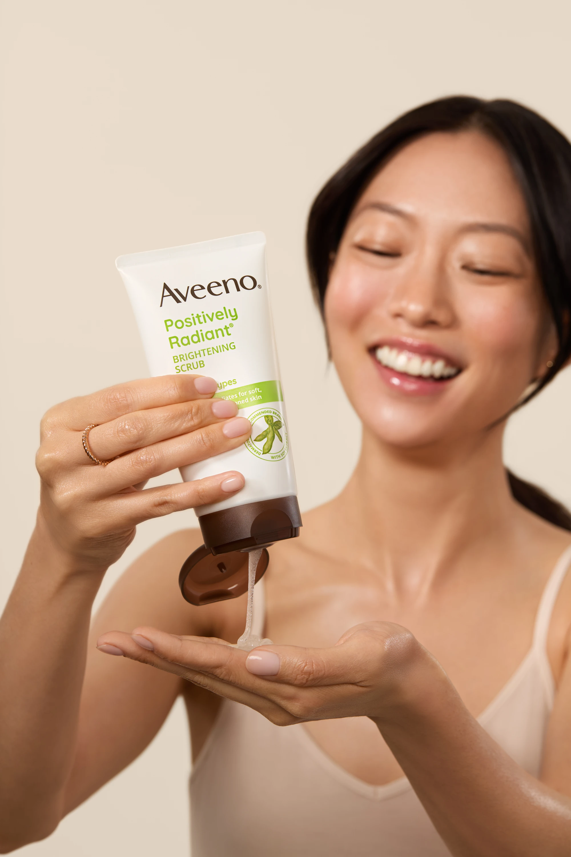A model dispensing Aveeno product into her palm.