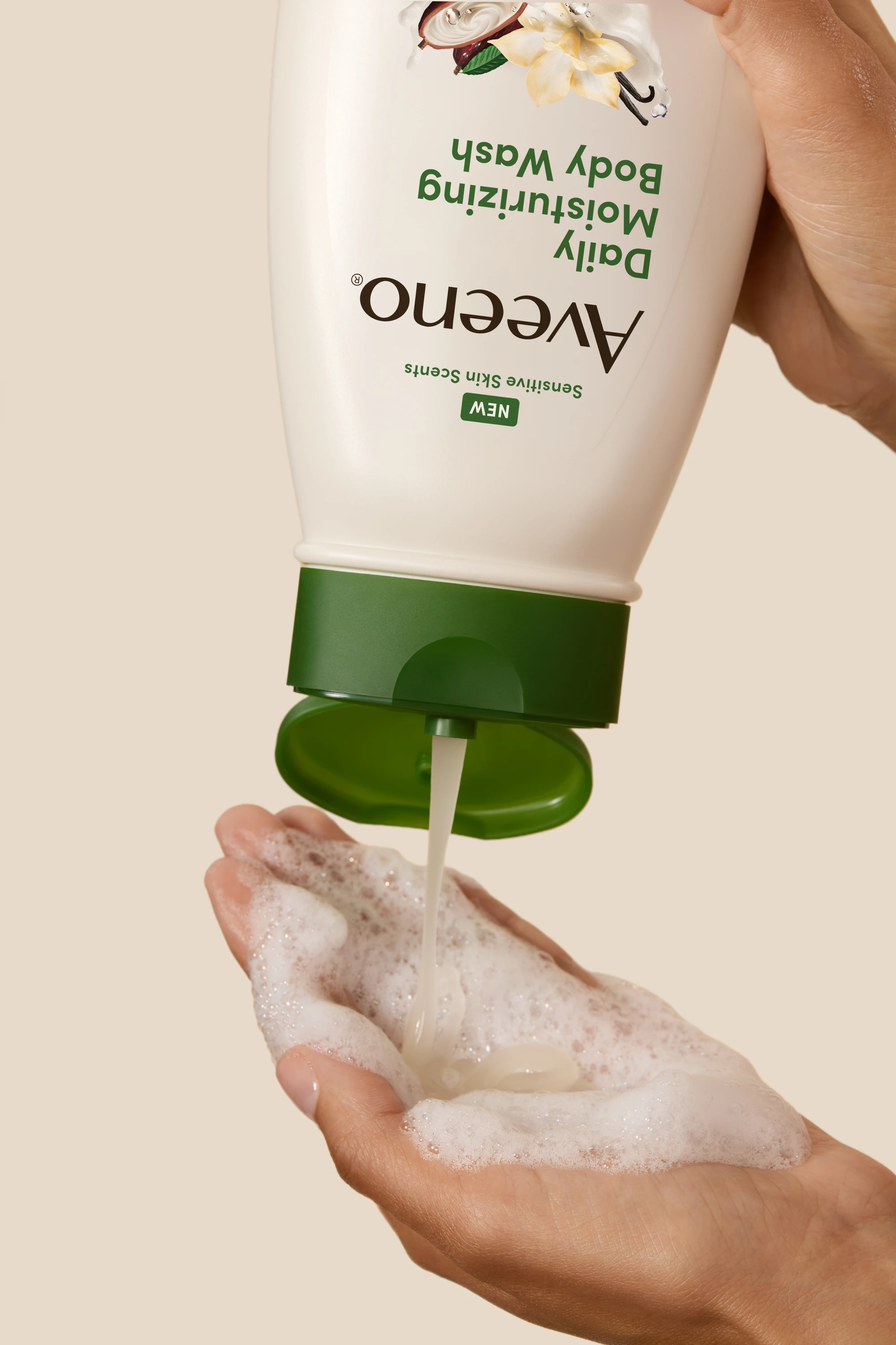 Hands dispensing Aveeno body wash into a palm.