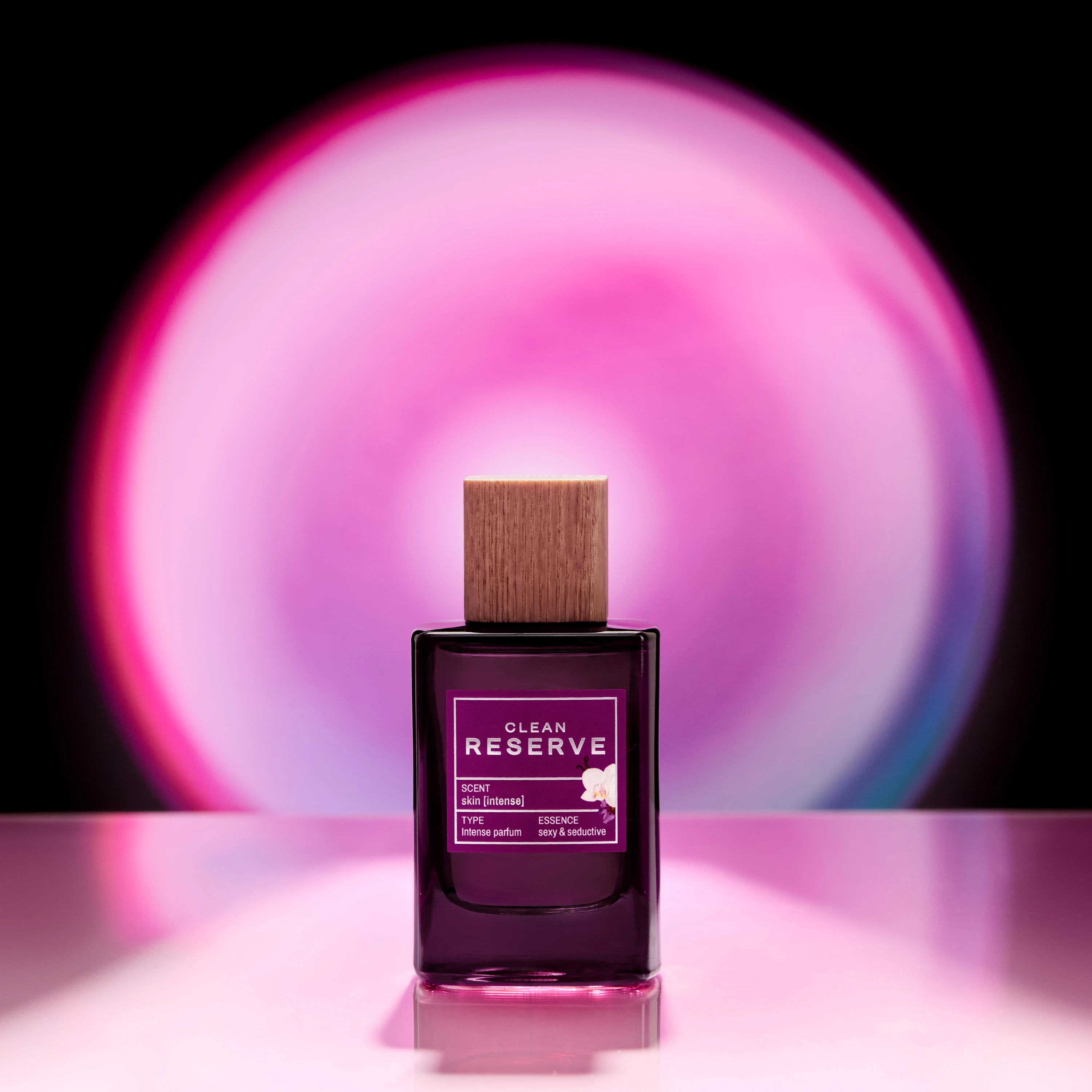 A Clean Reserve bottle silhouetted against a pink circular glow.