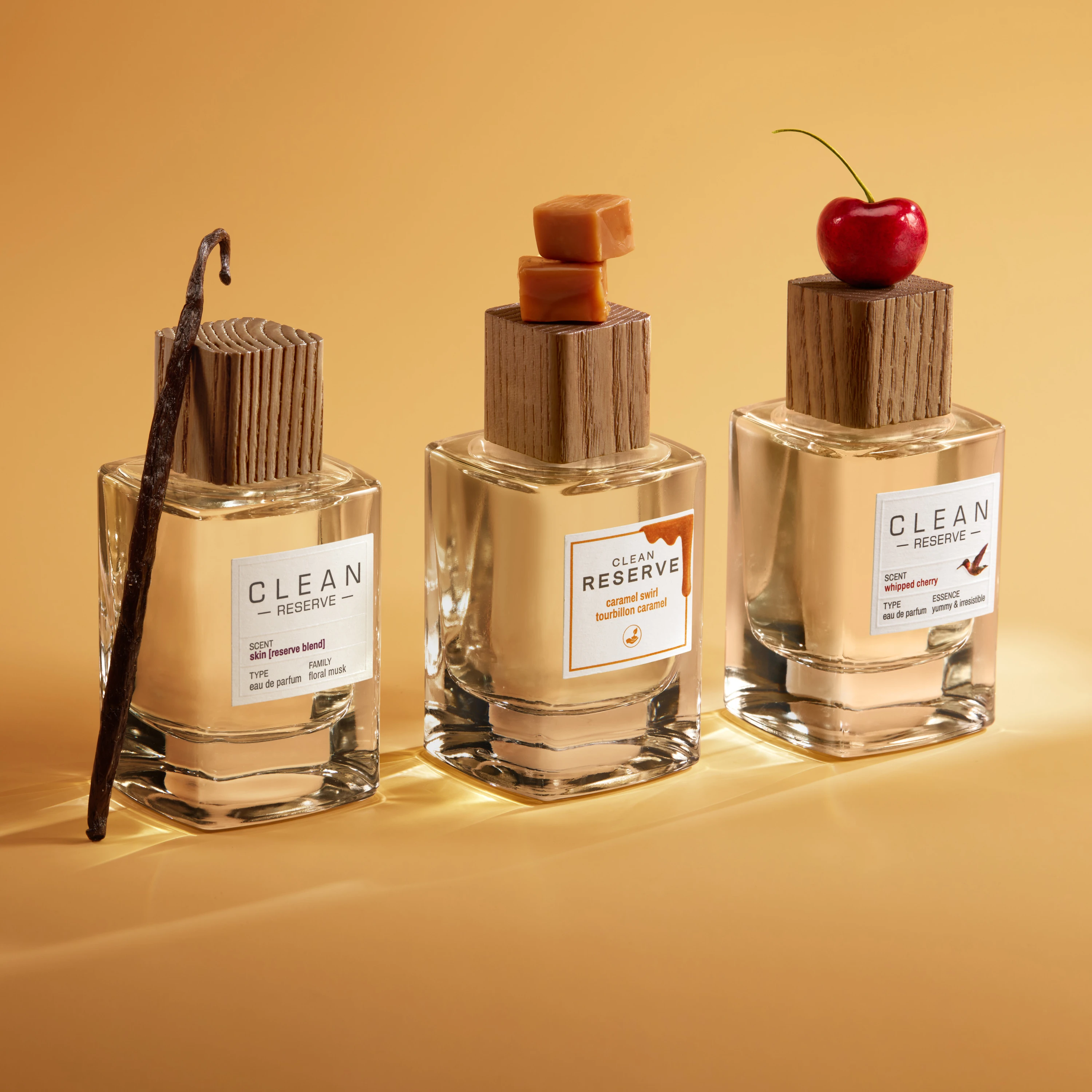 Three Clean Reserve bottles with vanilla pods, caramel and a cherry.