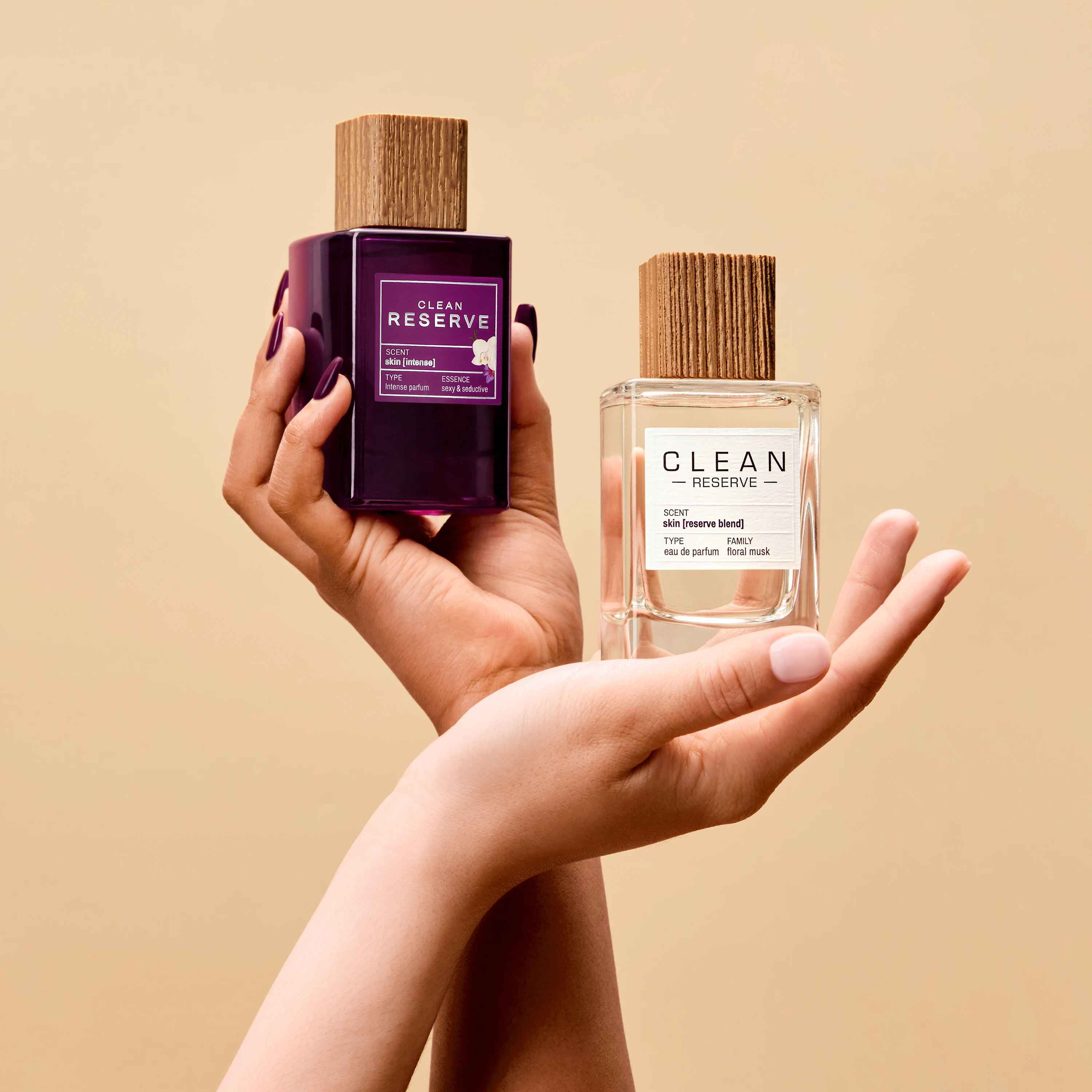 Hands holding two Clean Reserve fragrance bottles.