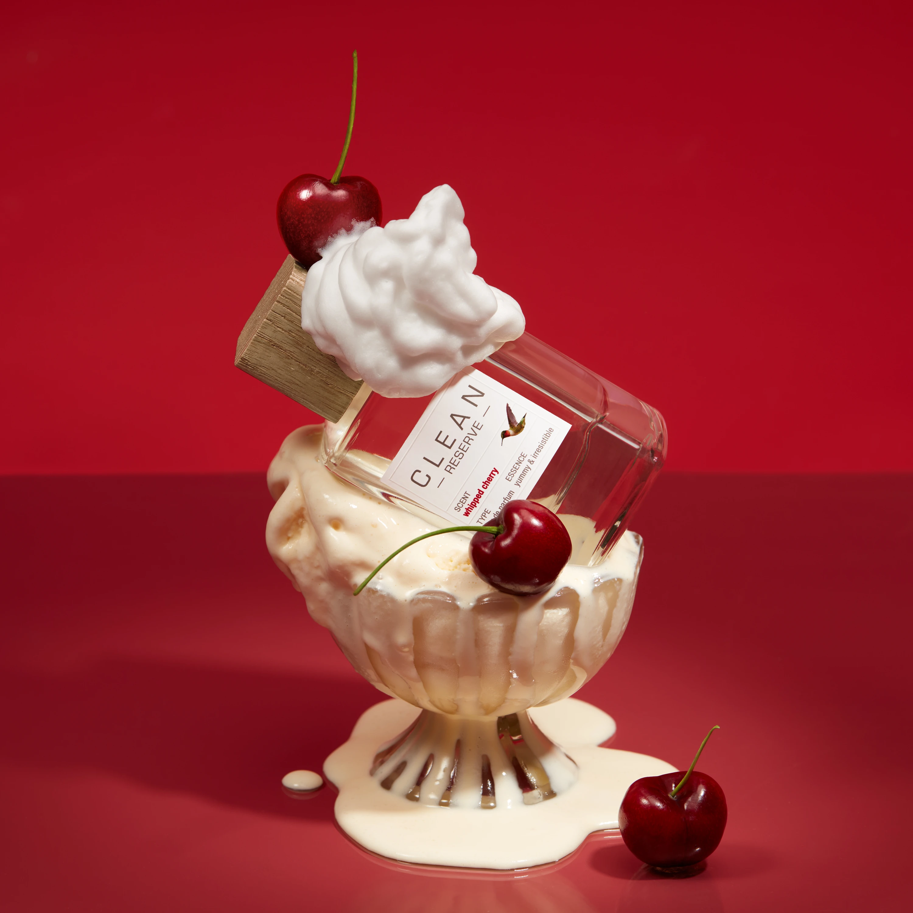 A Clean Reserve bottle in a dessert glass with whipped topping and cherries.