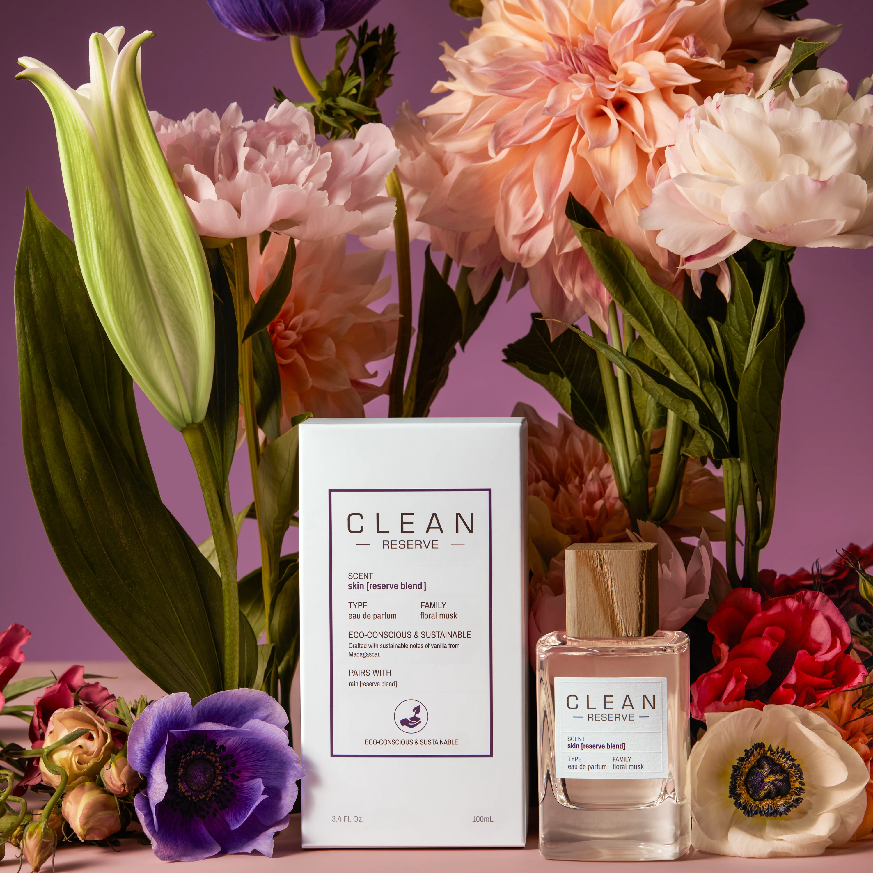 Clean Reserve packaging and bottle amid colorful flowers.