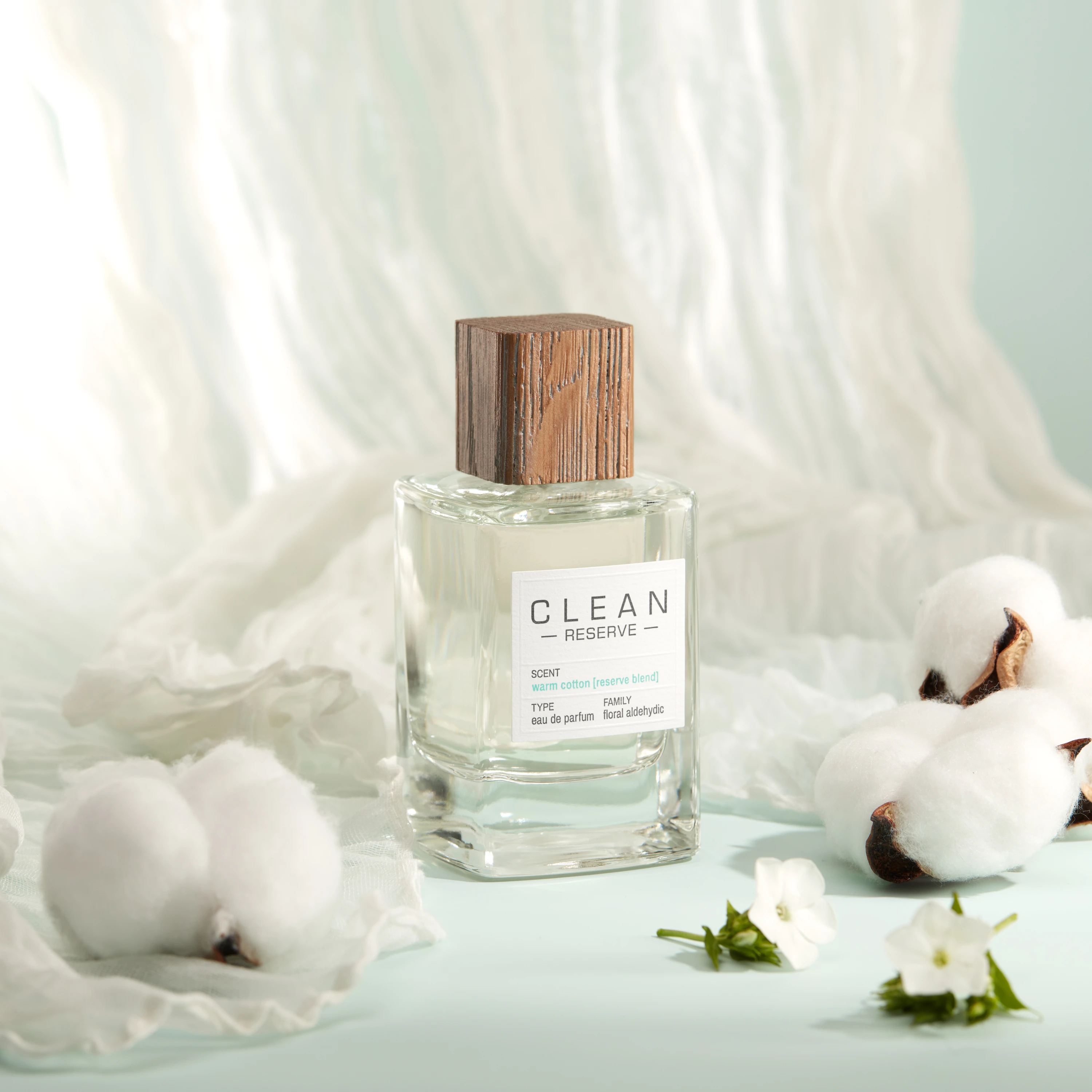 A Clean Reserve bottle surrounded by cotton on pale fabric.