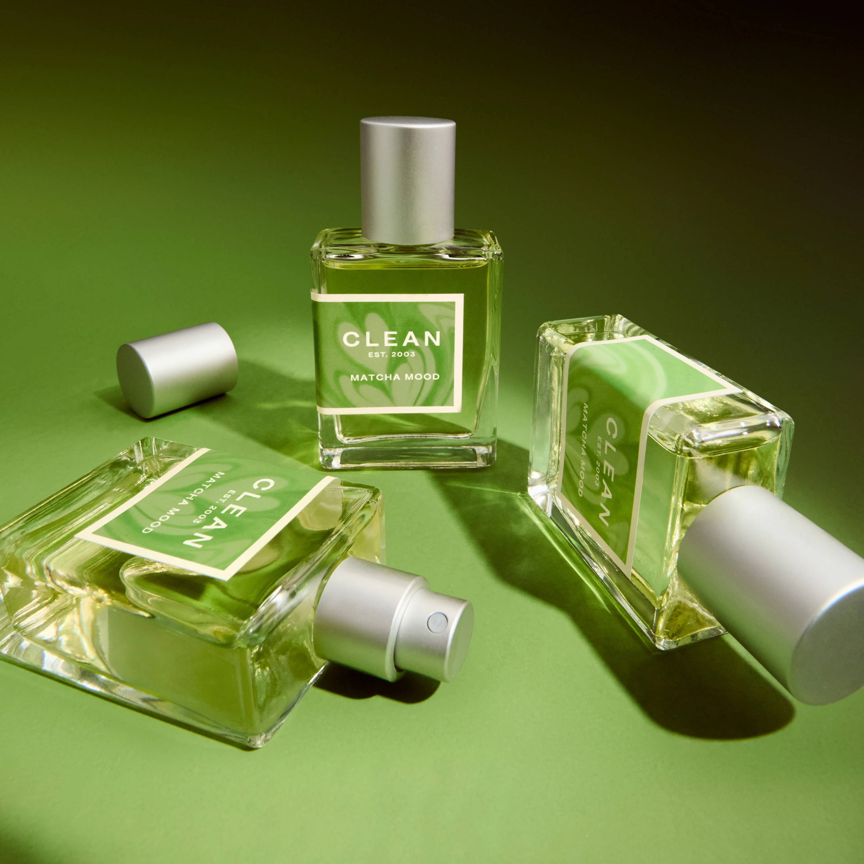 Green Clean fragrance bottles arranged against a green background.