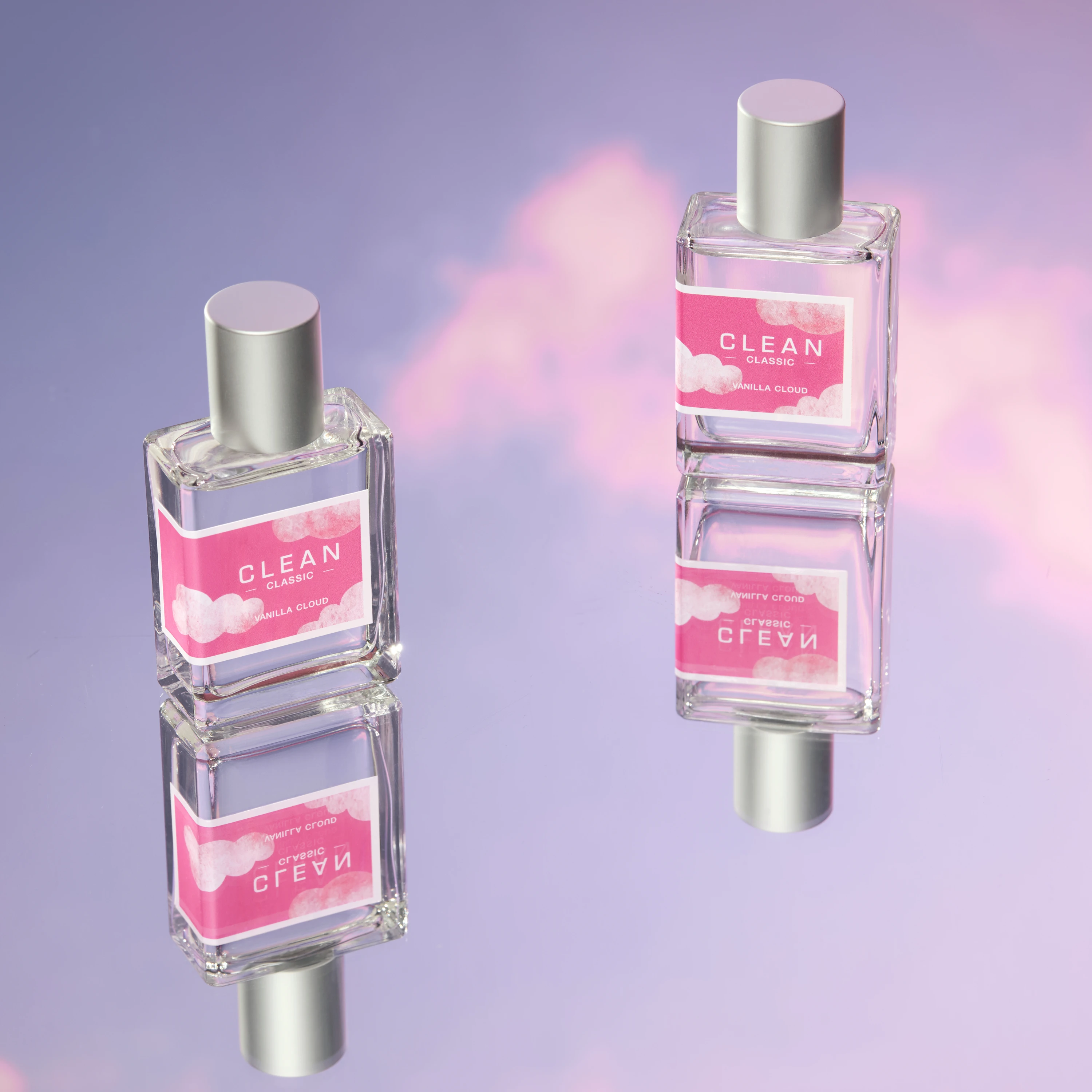 Pink Clean fragrance bottles reflected on a mirrored surface.