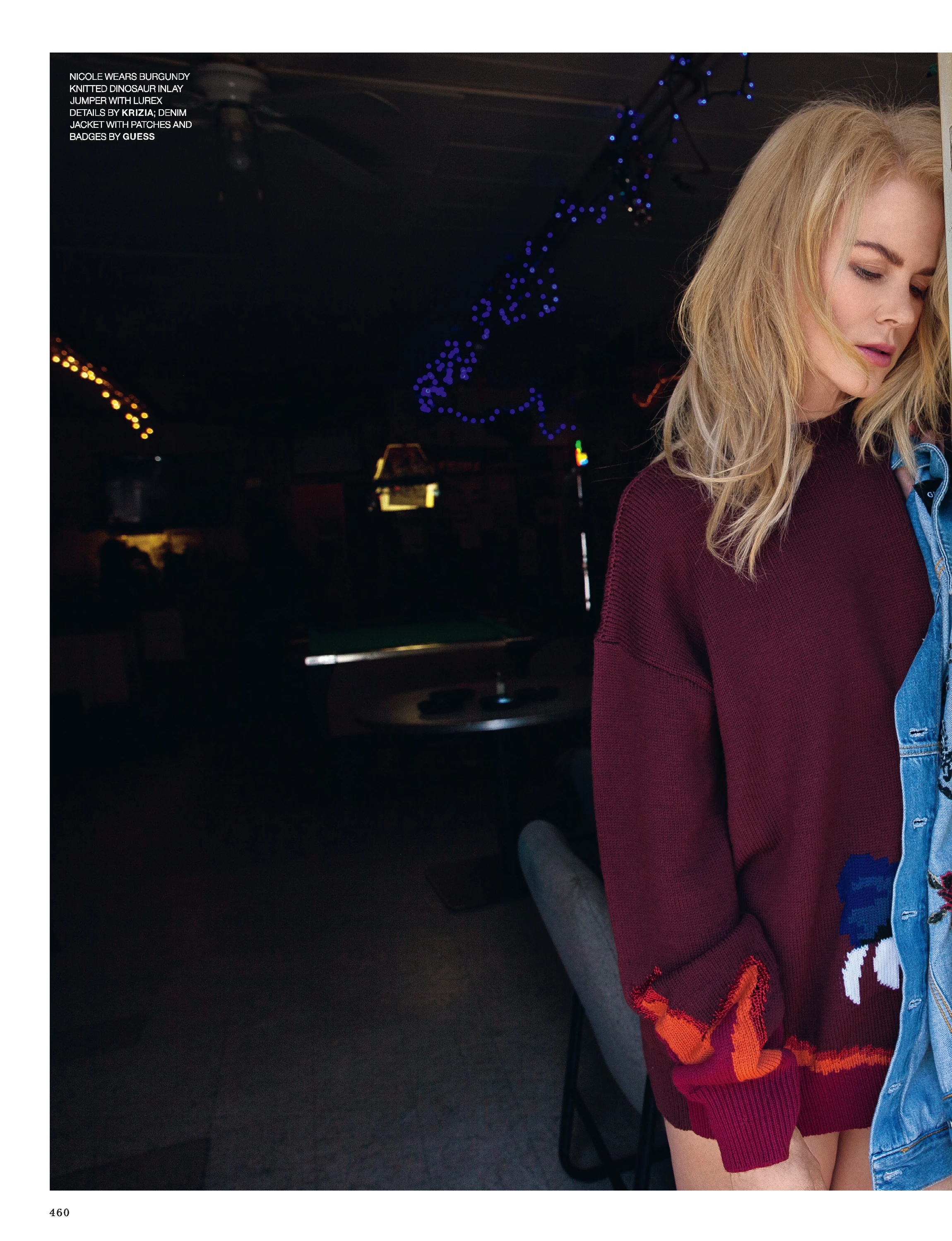 Nicole Kidman posing indoors in a dark red jacket.