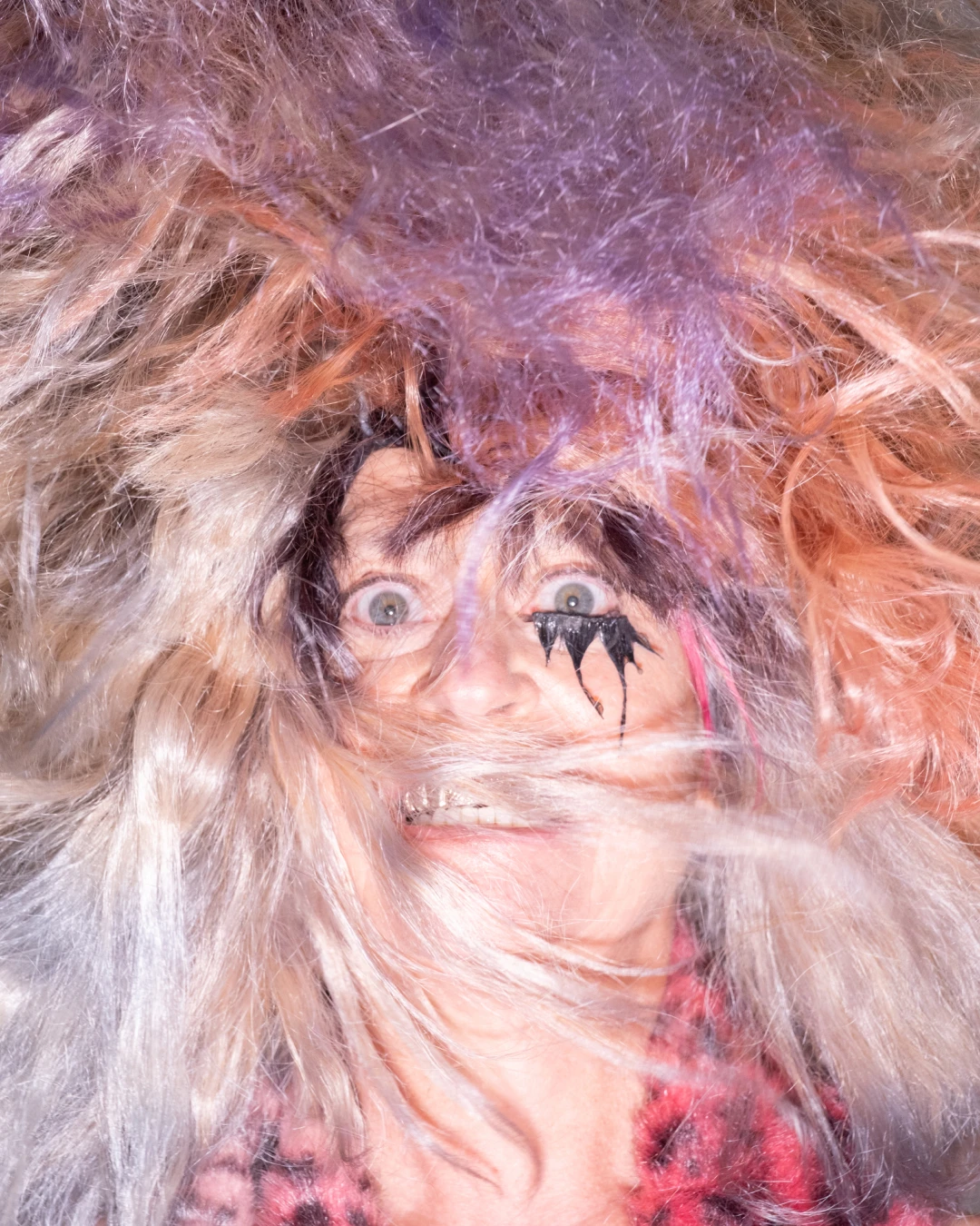 Close editorial portrait of Peaches framed by wispy hair.