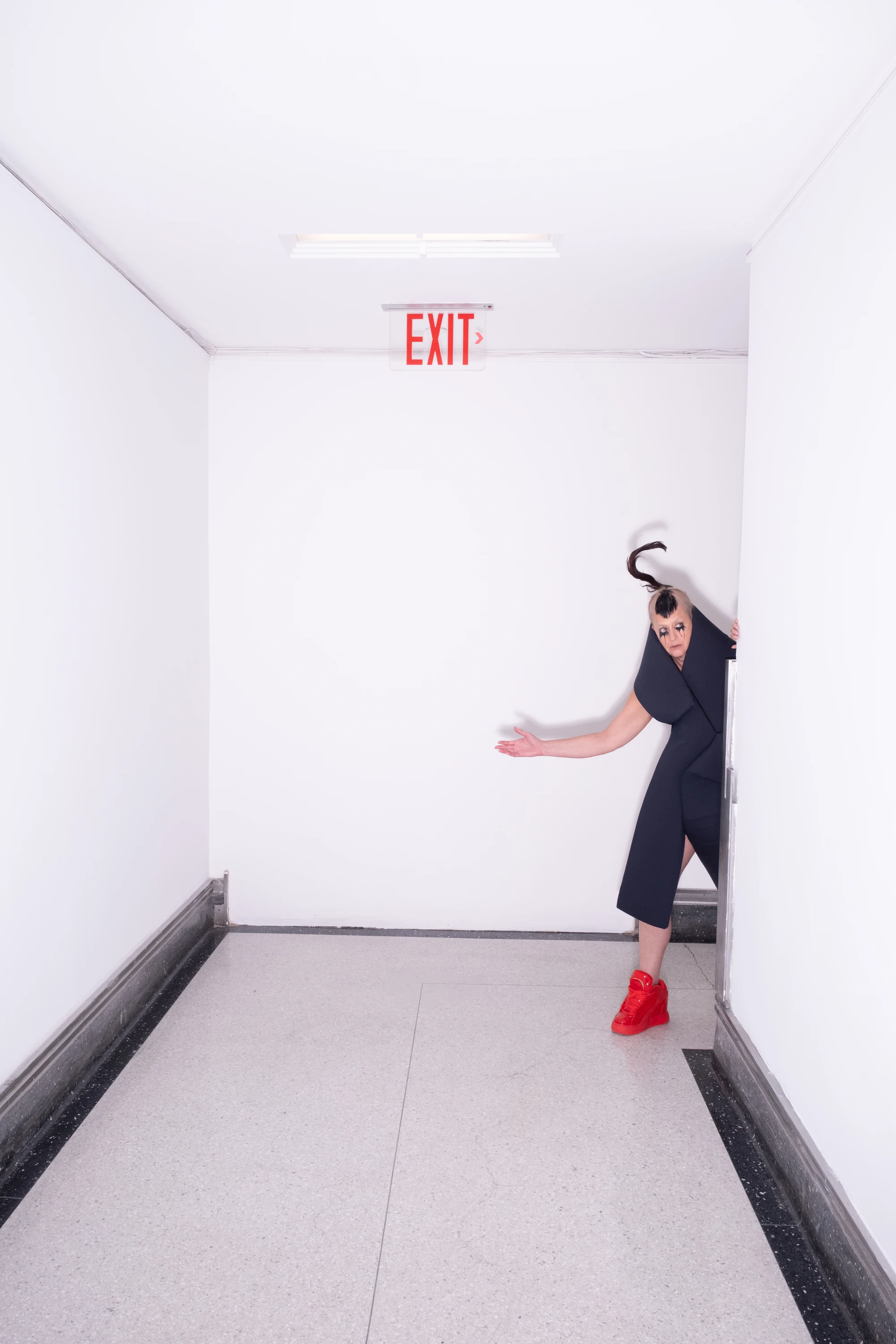 Peaches leaning into a white hallway.