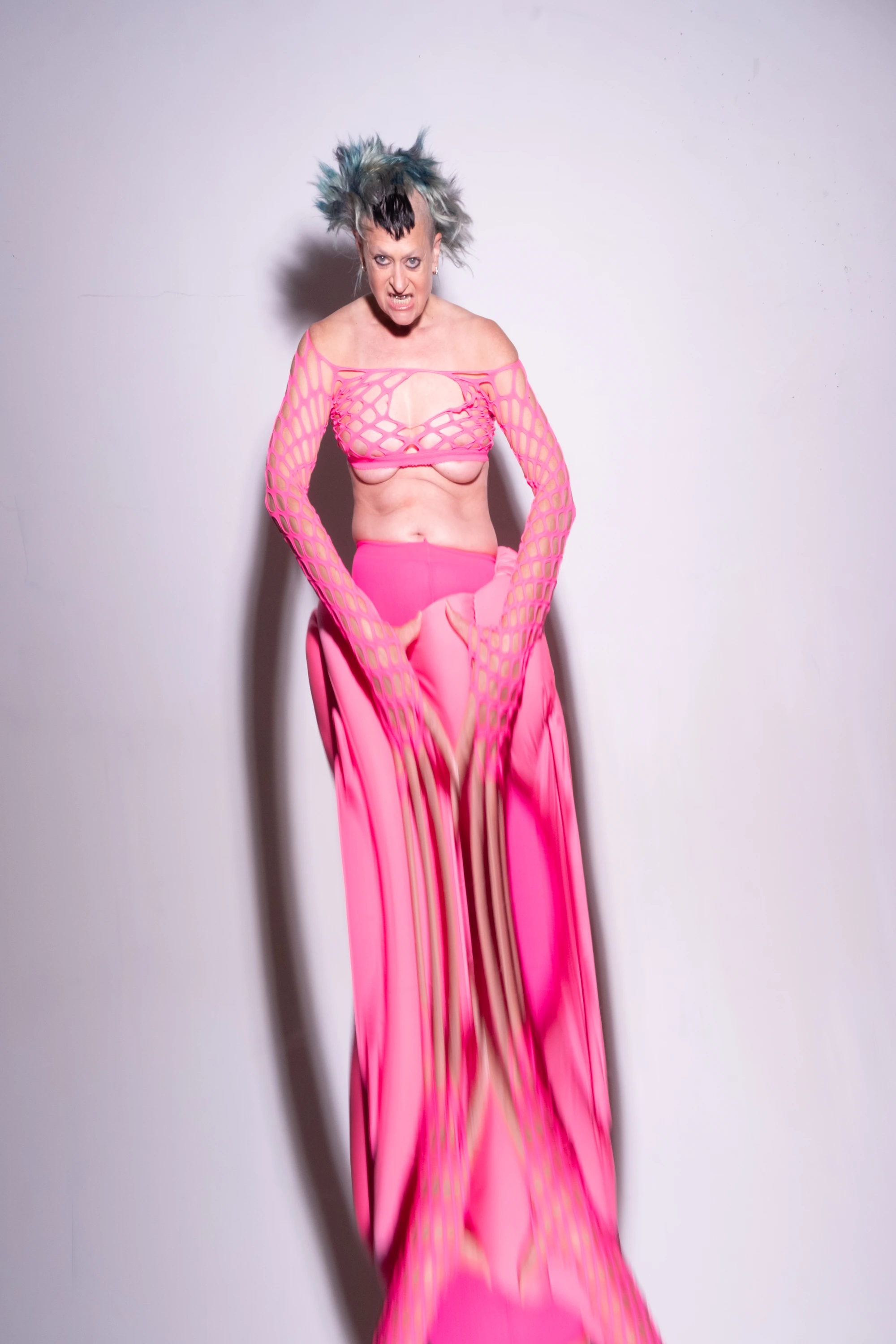 Peaches standing in a long pink outfit.