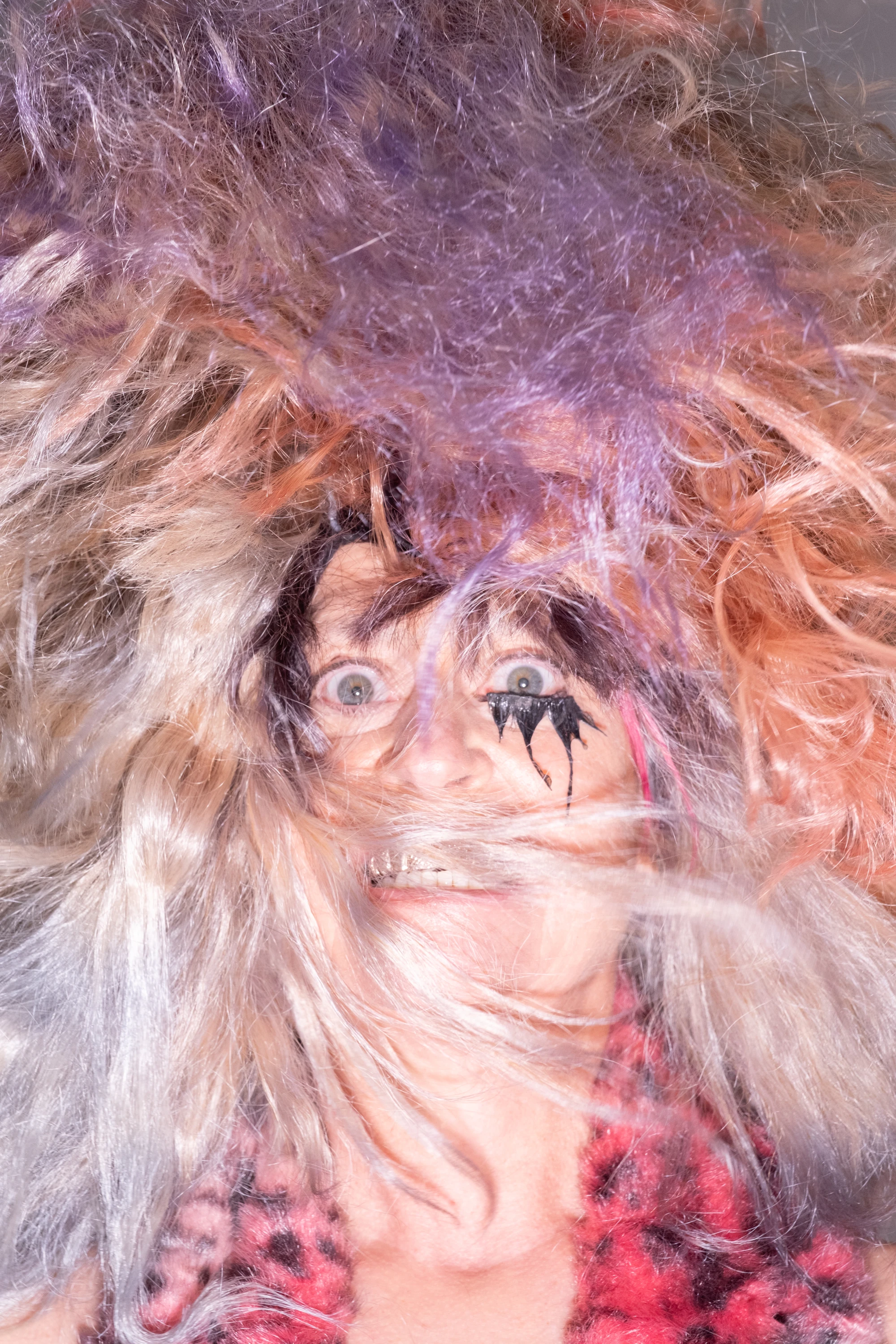 Close portrait of Peaches framed by wispy hair.