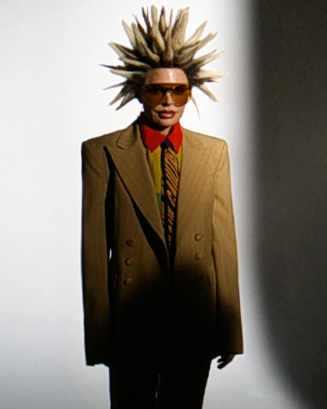 Lisa Rinna wearing sunglasses and a suit with spiked hair.