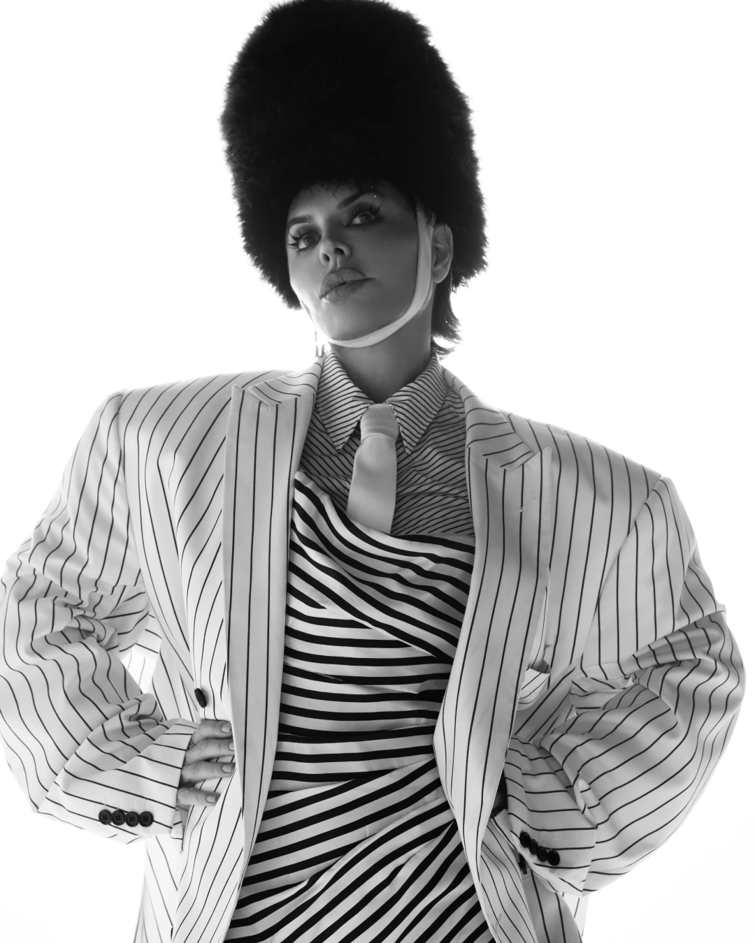 Black-and-white editorial portrait of Lisa Rinna in a striped jacket.