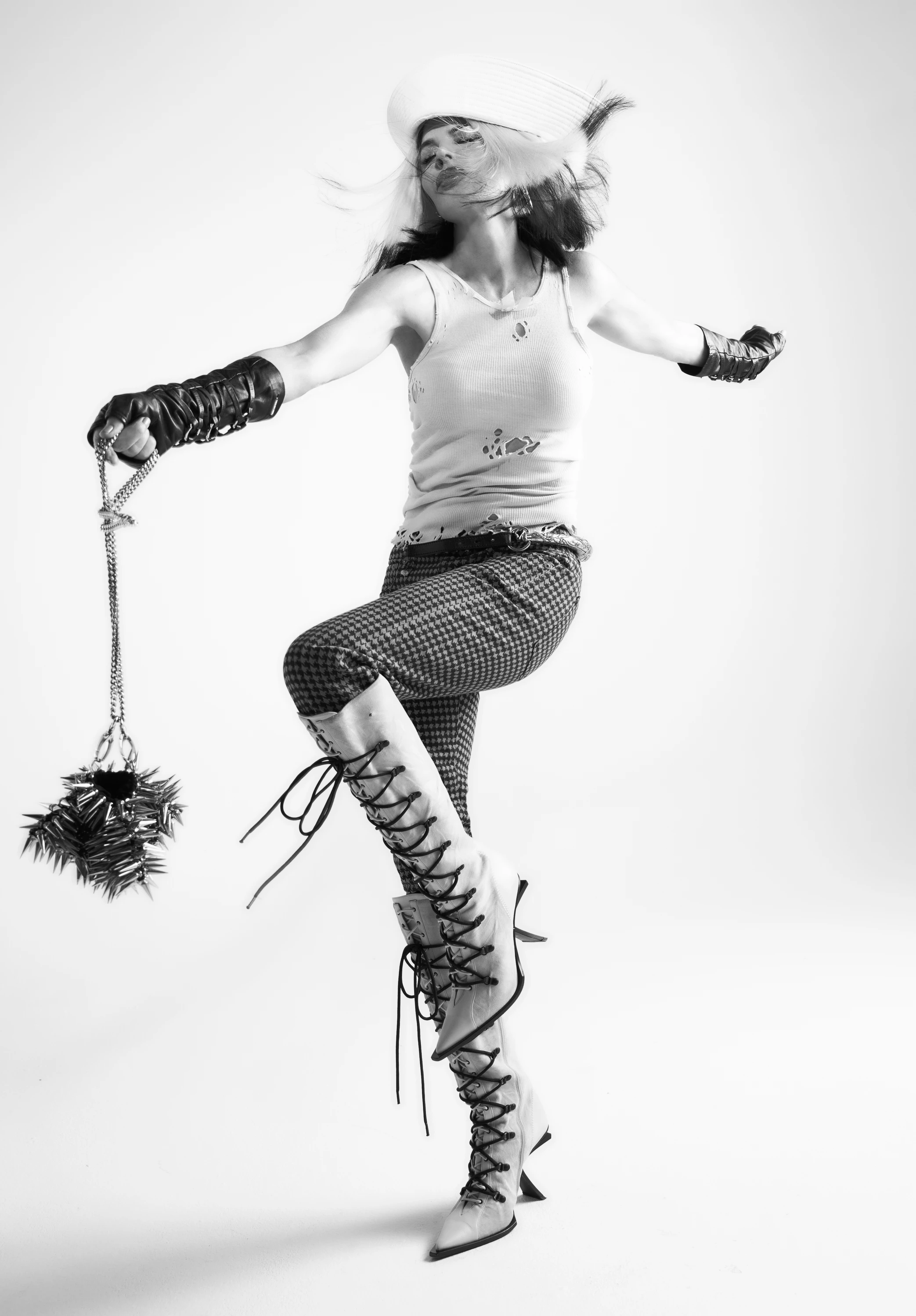 Lisa Rinna raising one leg while holding a decorative prop.