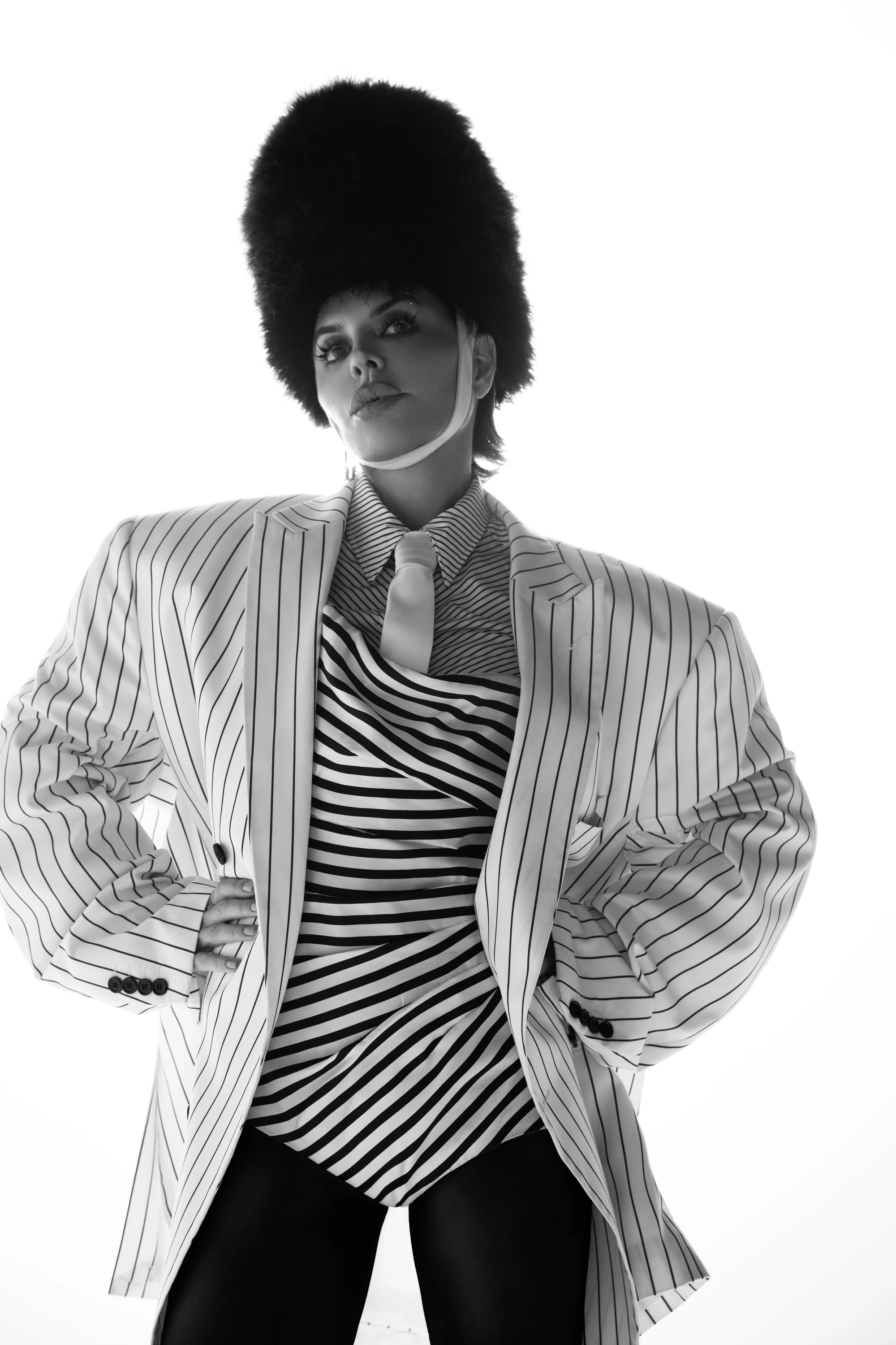 Black-and-white portrait of Lisa Rinna in a striped jacket and tall hat.