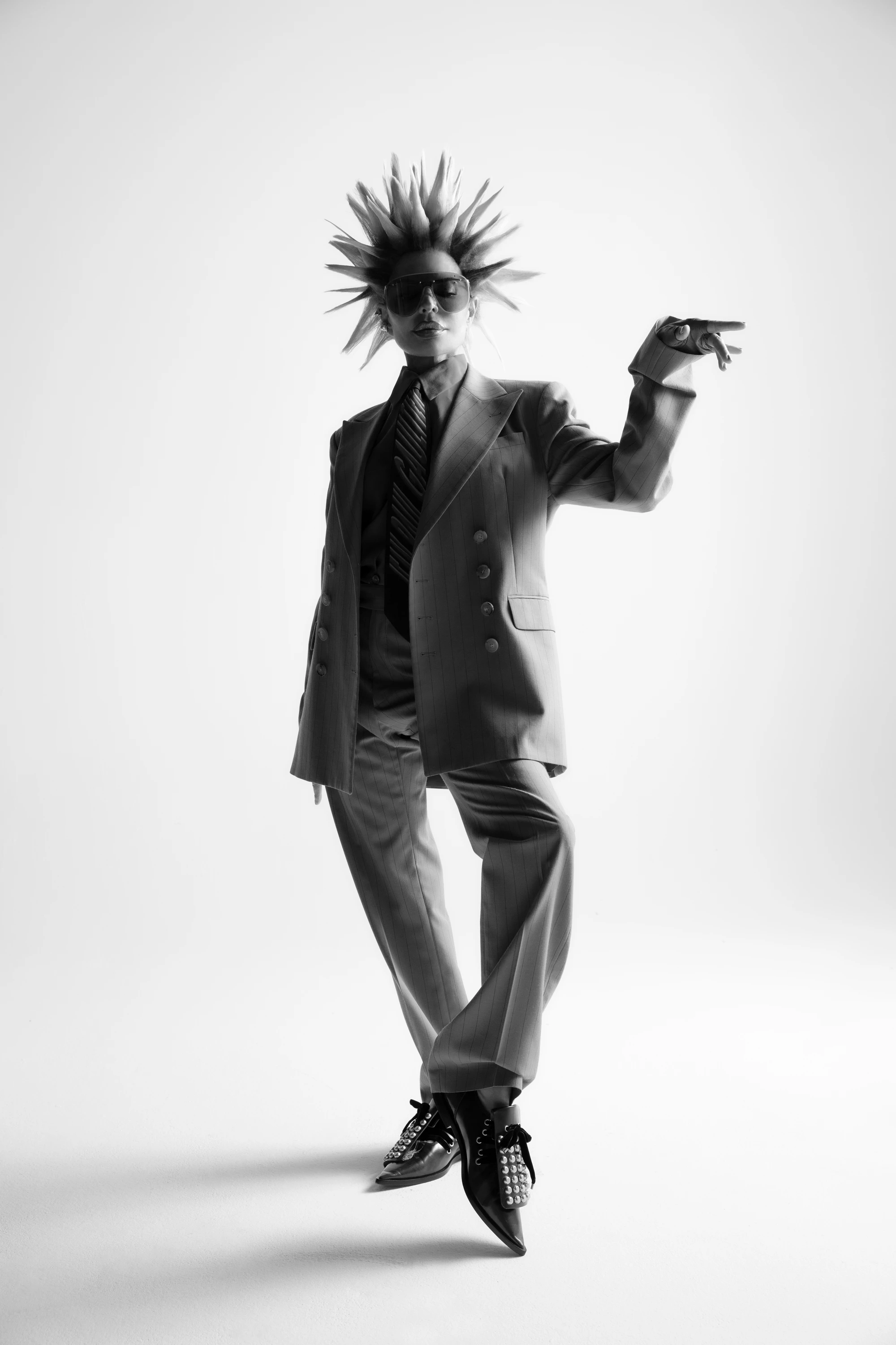Lisa Rinna raising one hand in a dark suit.