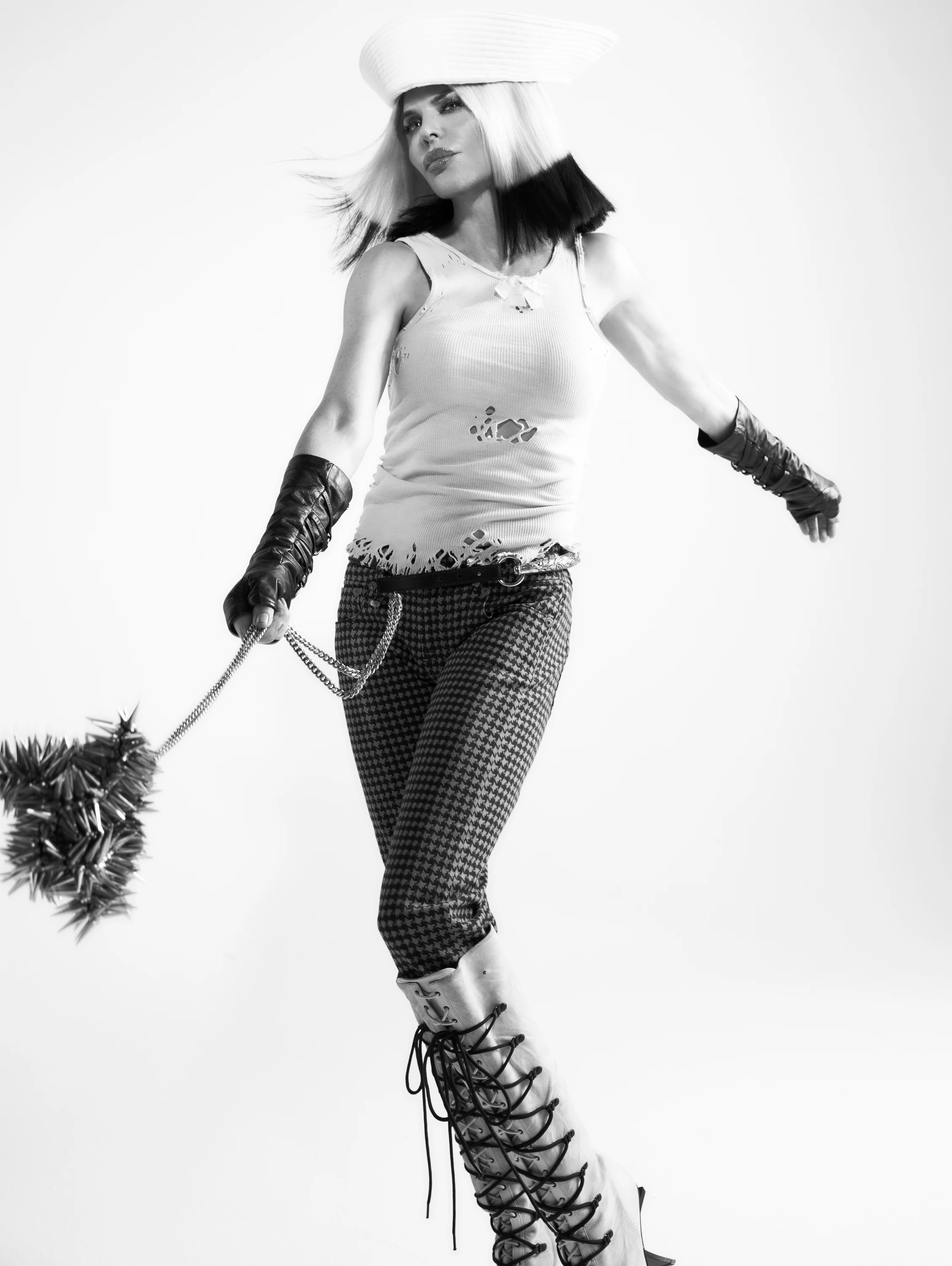 Lisa Rinna posing with a hat, gloves and patterned boots.