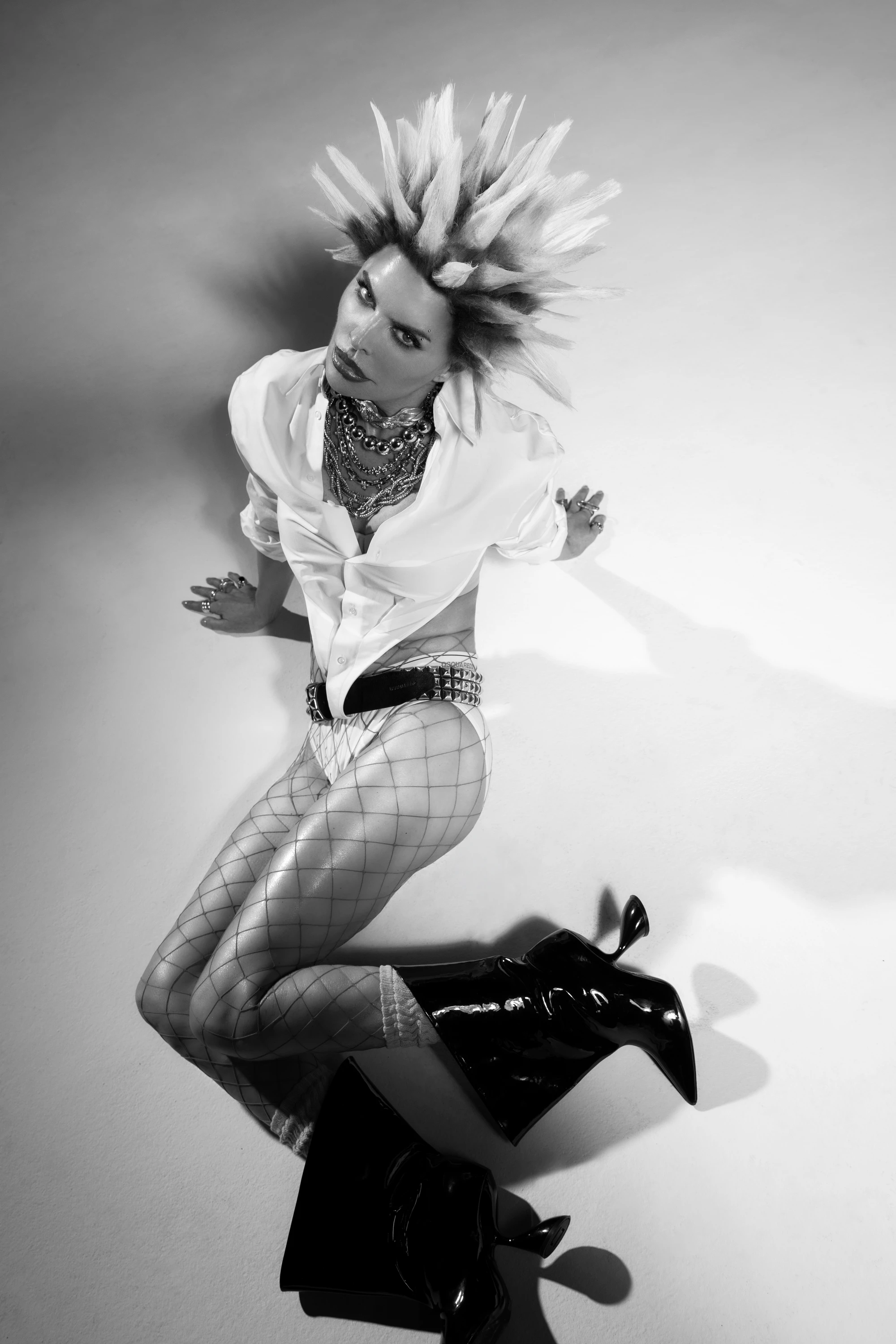 Black-and-white portrait of Lisa Rinna crouching with spiked hair.