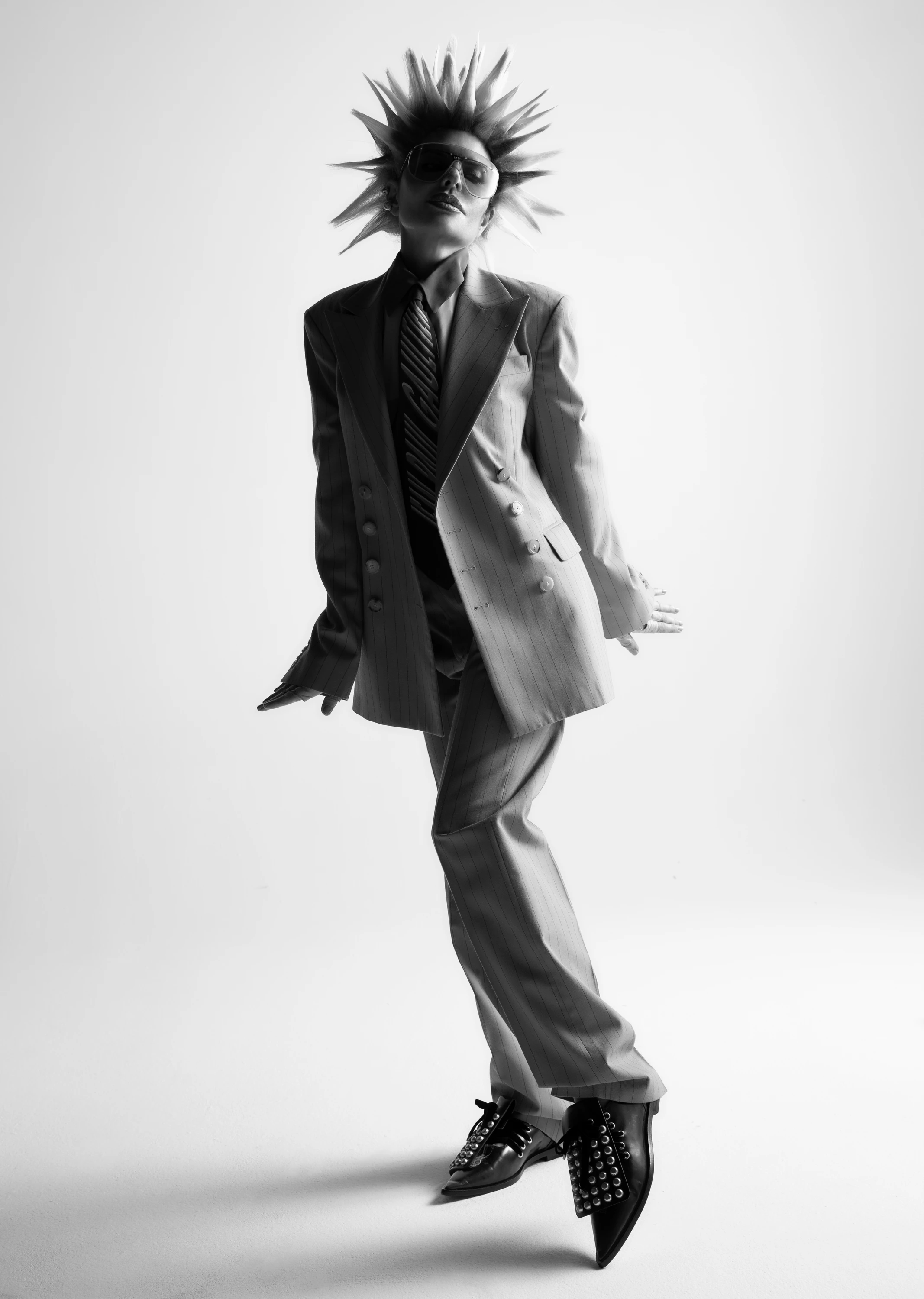Lisa Rinna posing in a suit with a spiked hairstyle.