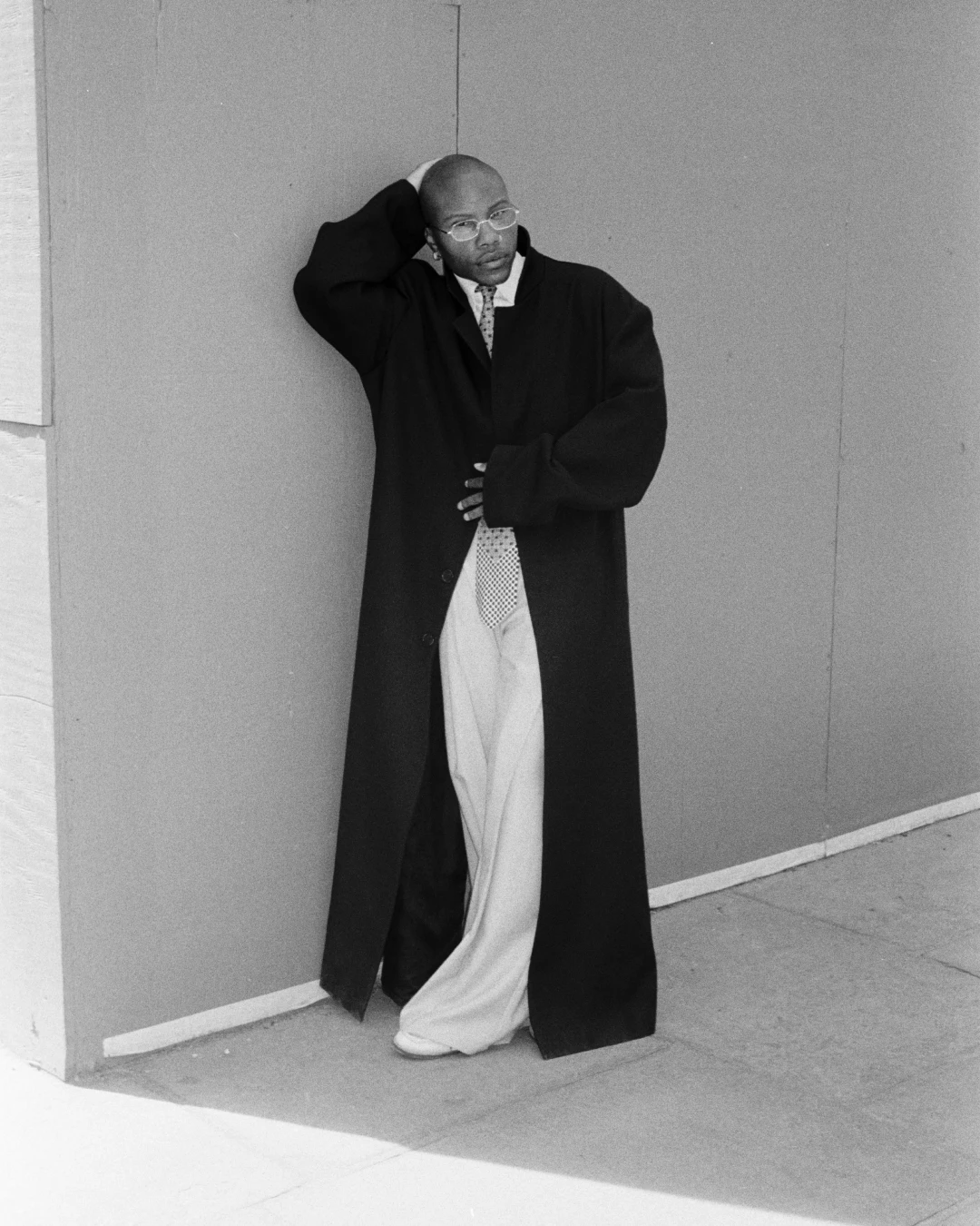 Black-and-white portrait of TYGAPAW leaning against a wall.