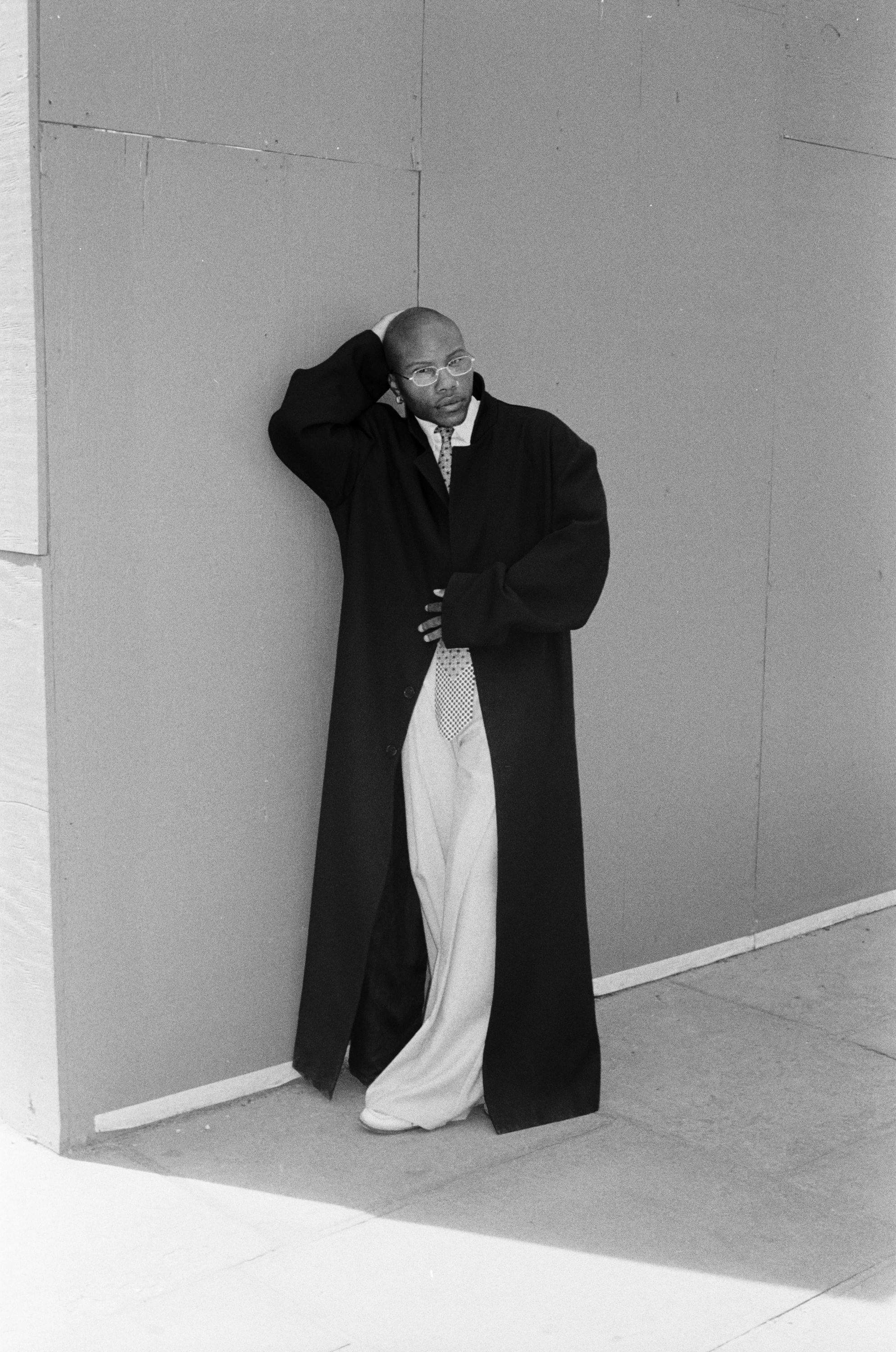 Black-and-white portrait of TYGAPAW leaning against a wall.