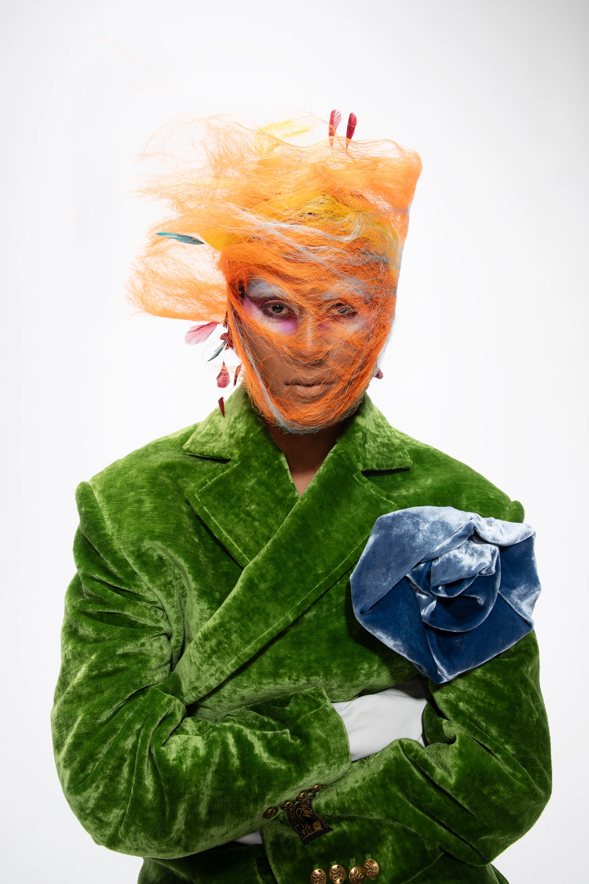 Richie Shazam wearing a green outfit with a blue flower.
