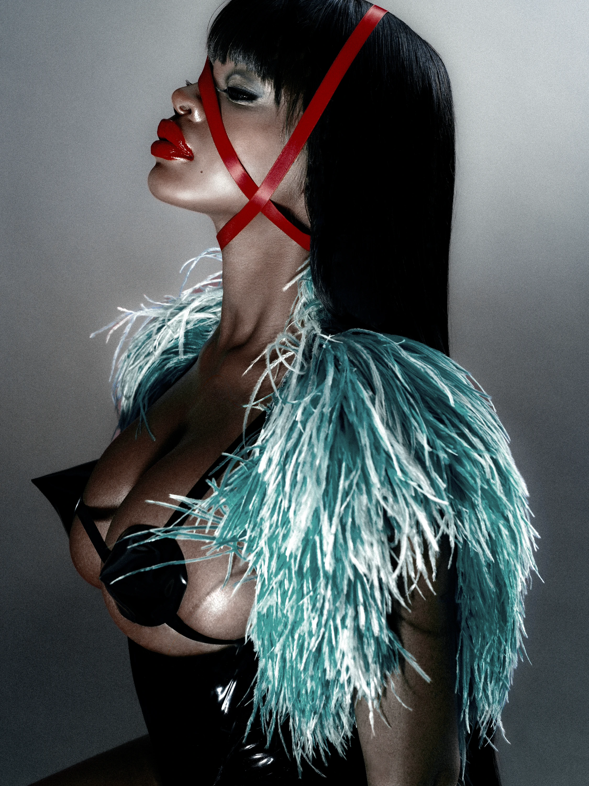 JT in profile wearing a feathered outfit and red facial straps.