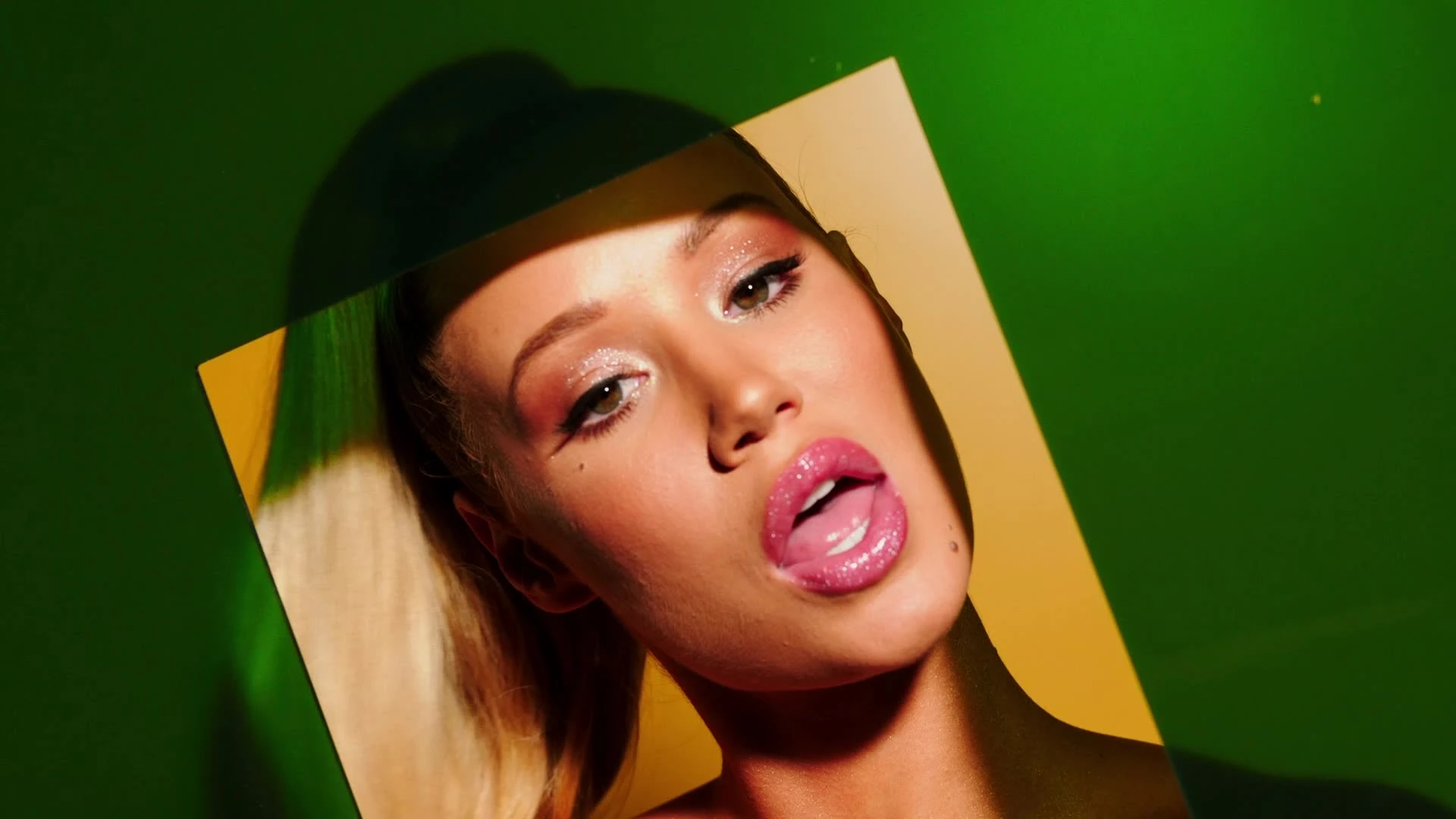 A close portrait framed by green-and-yellow shapes.