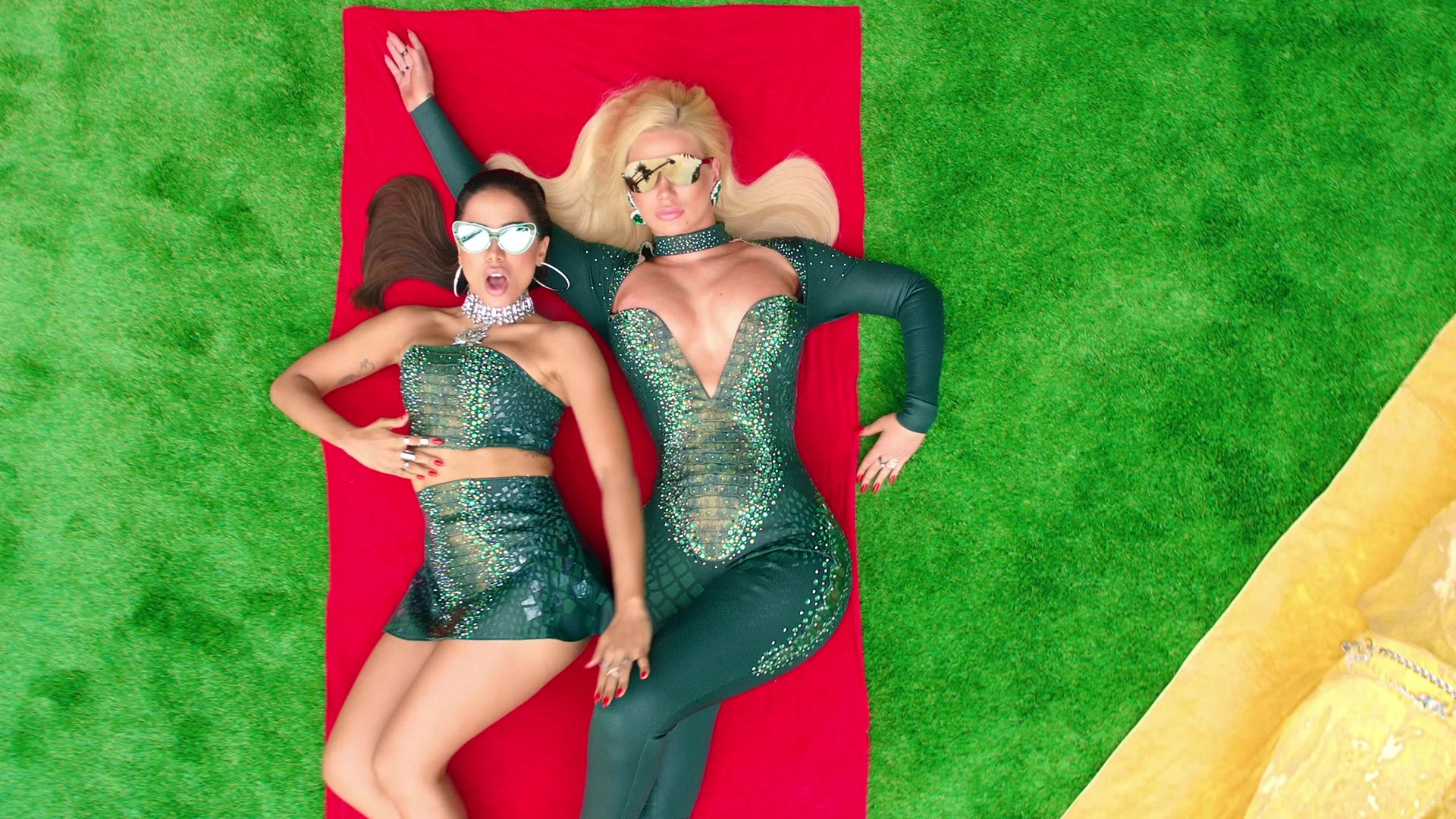 An overhead portrait of Iggy Azalea and Anitta on a red mat.