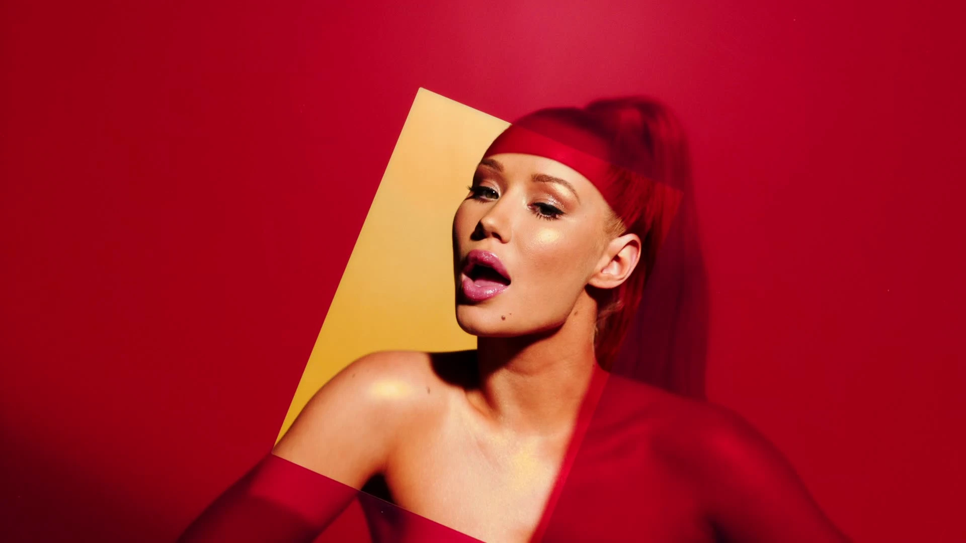 A performer posing in a red geometric cutout.