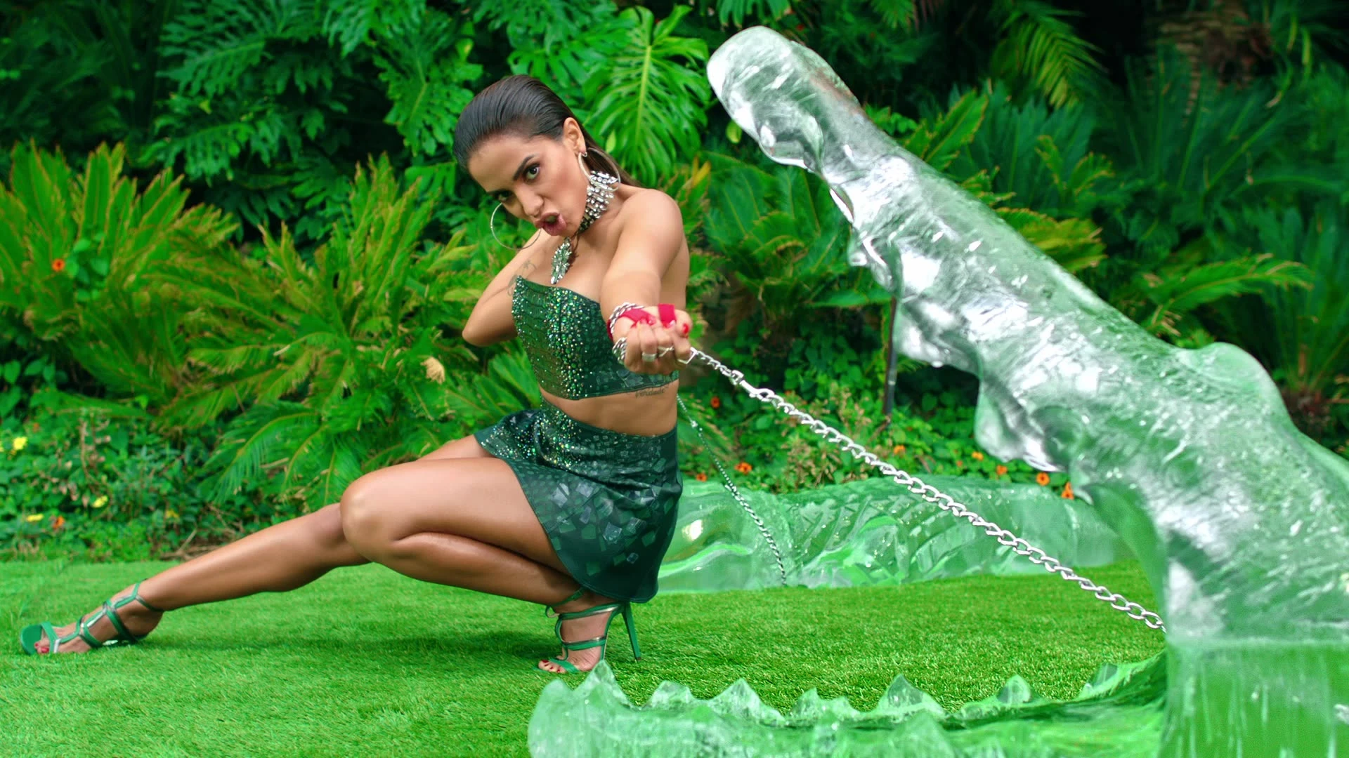 Anitta posing beside a clear animal sculpture on grass.