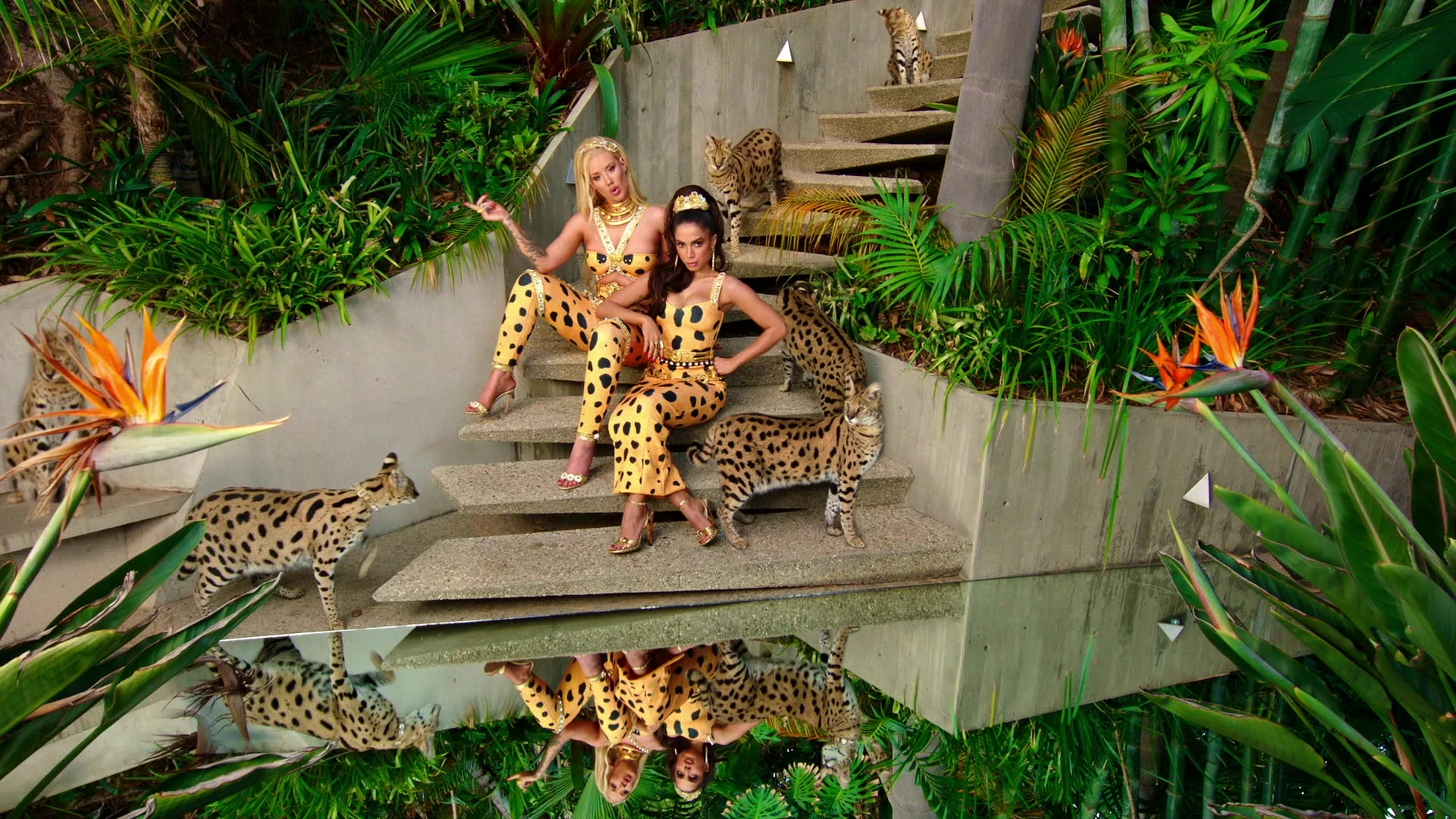 Performers posing on steps with spotted cats.