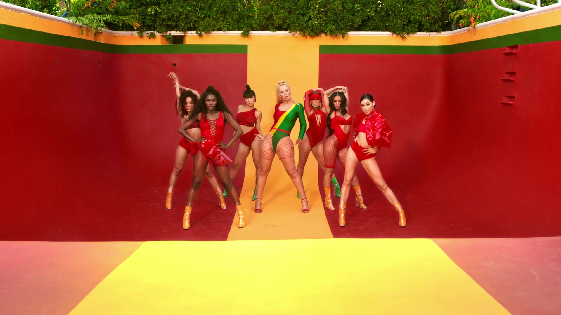 Dancers performing inside a red-and-yellow pool.