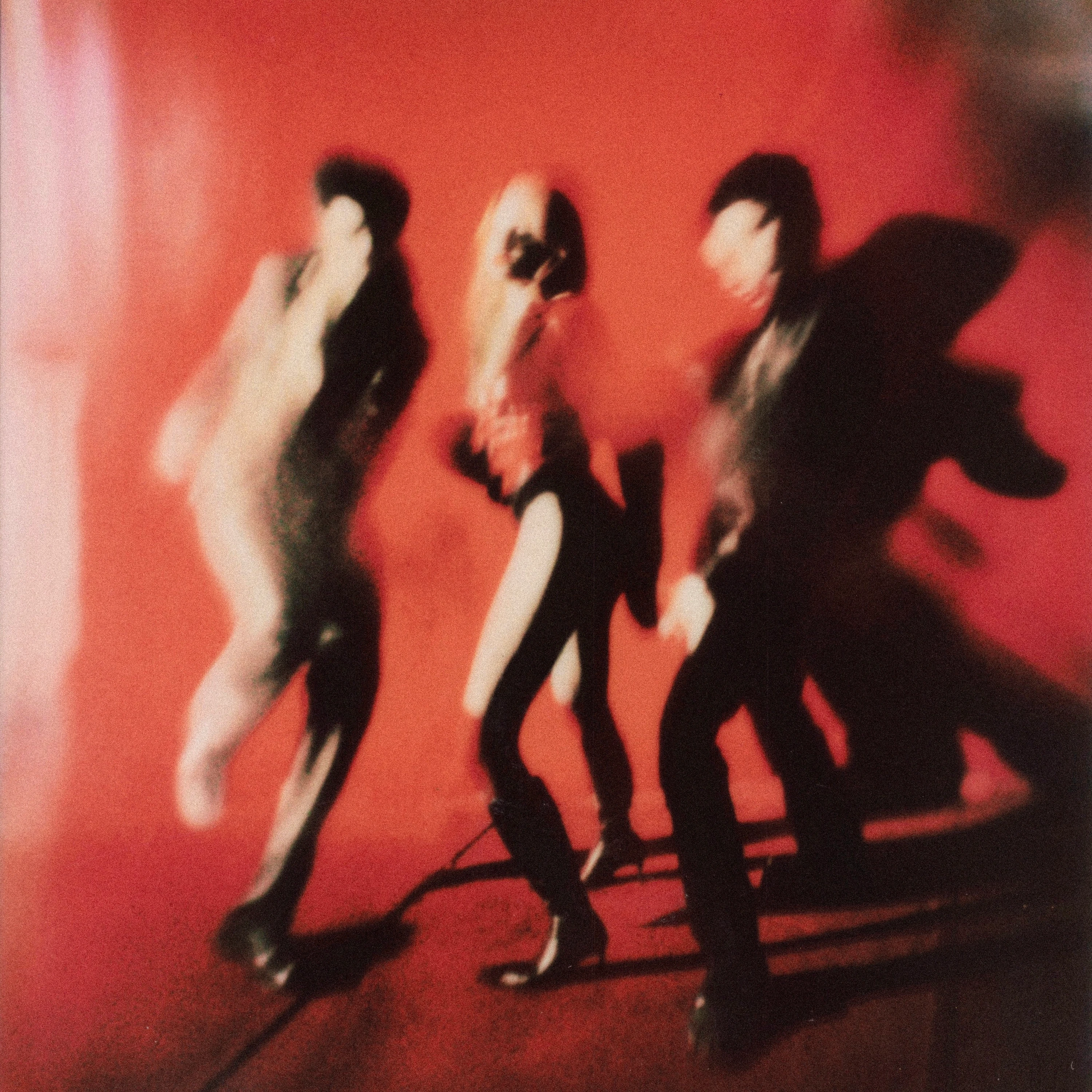 MUNA performing against a red backdrop.