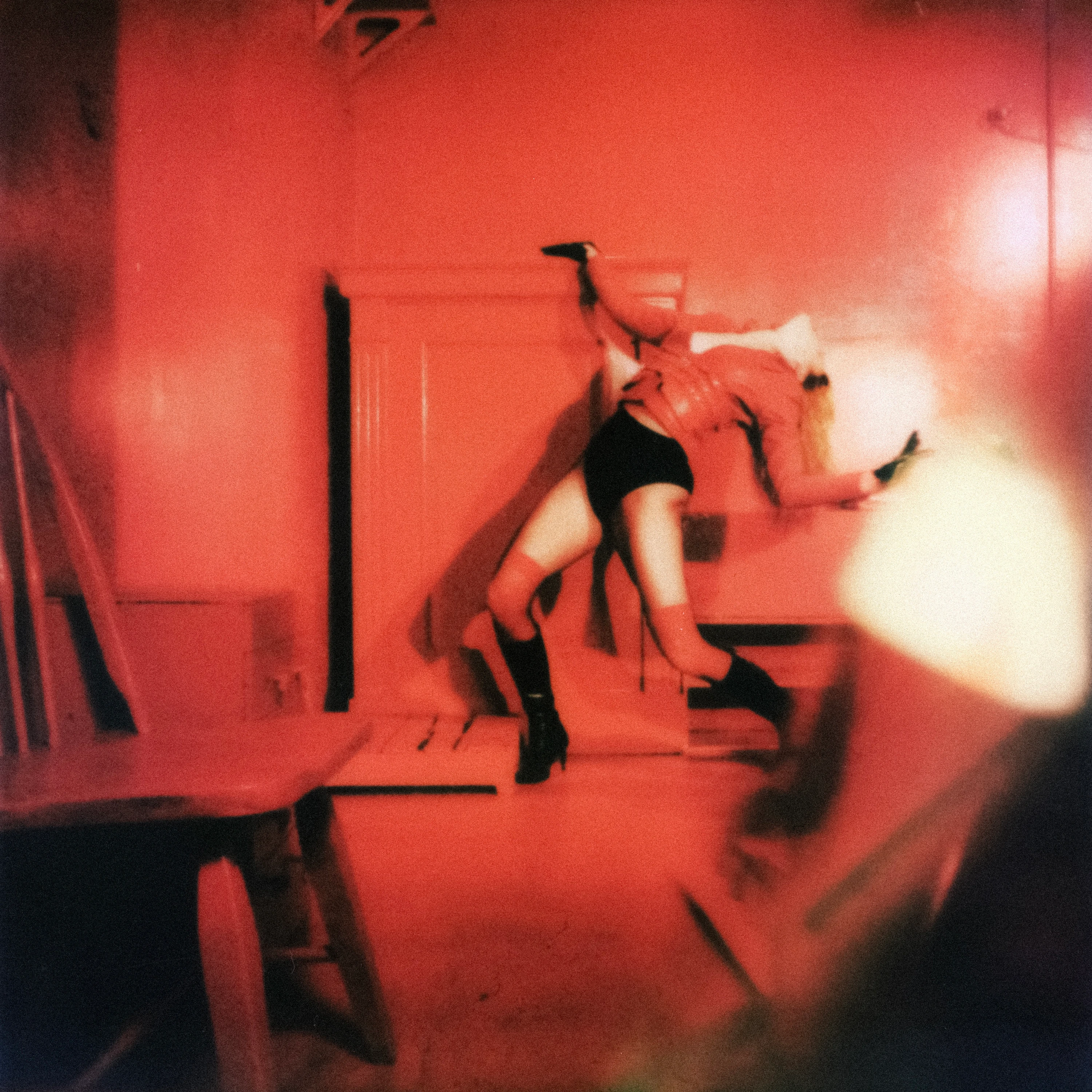 MUNA performing in a red-lit room.