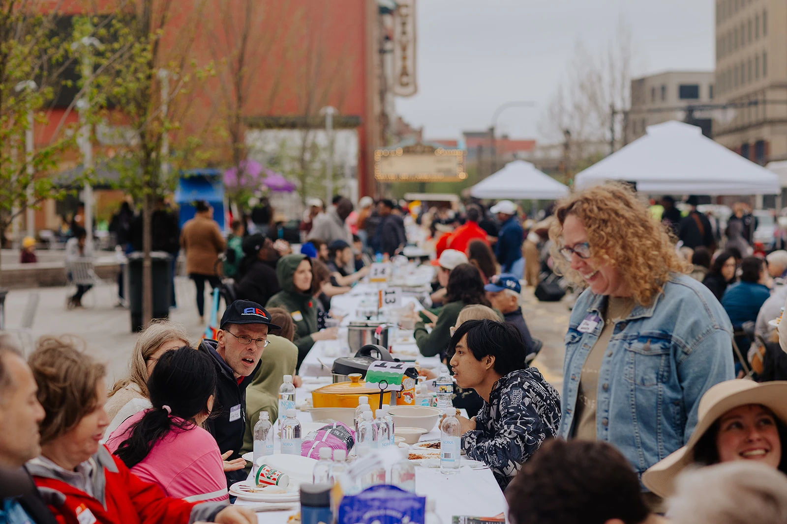 Participants sharing food and conversation at outdoor tables.