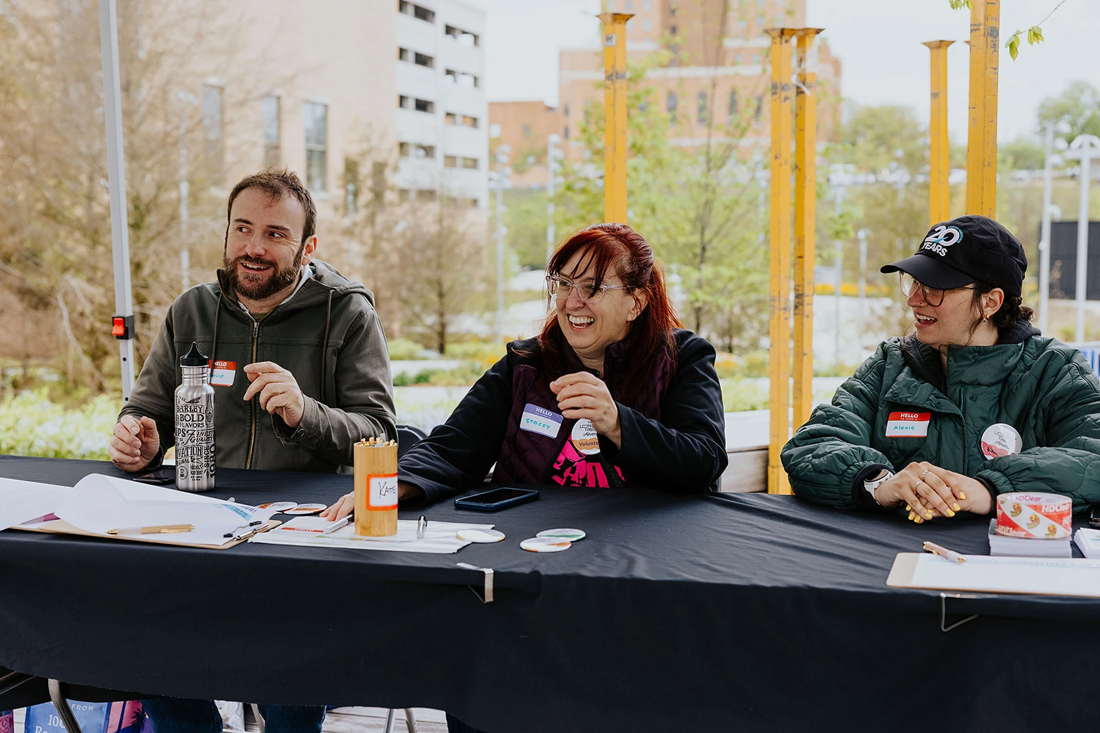Three participants talking at a table with microphones.