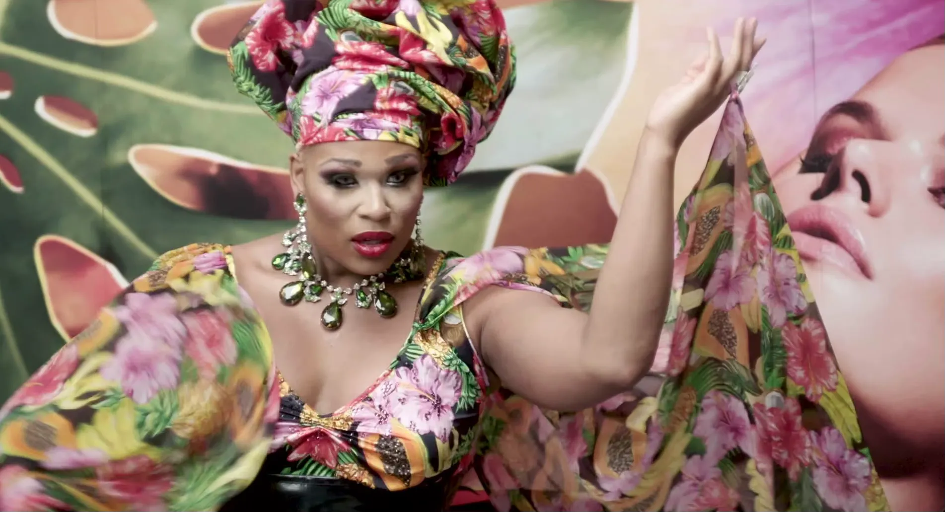 A performer wearing a floral outfit and headwrap.