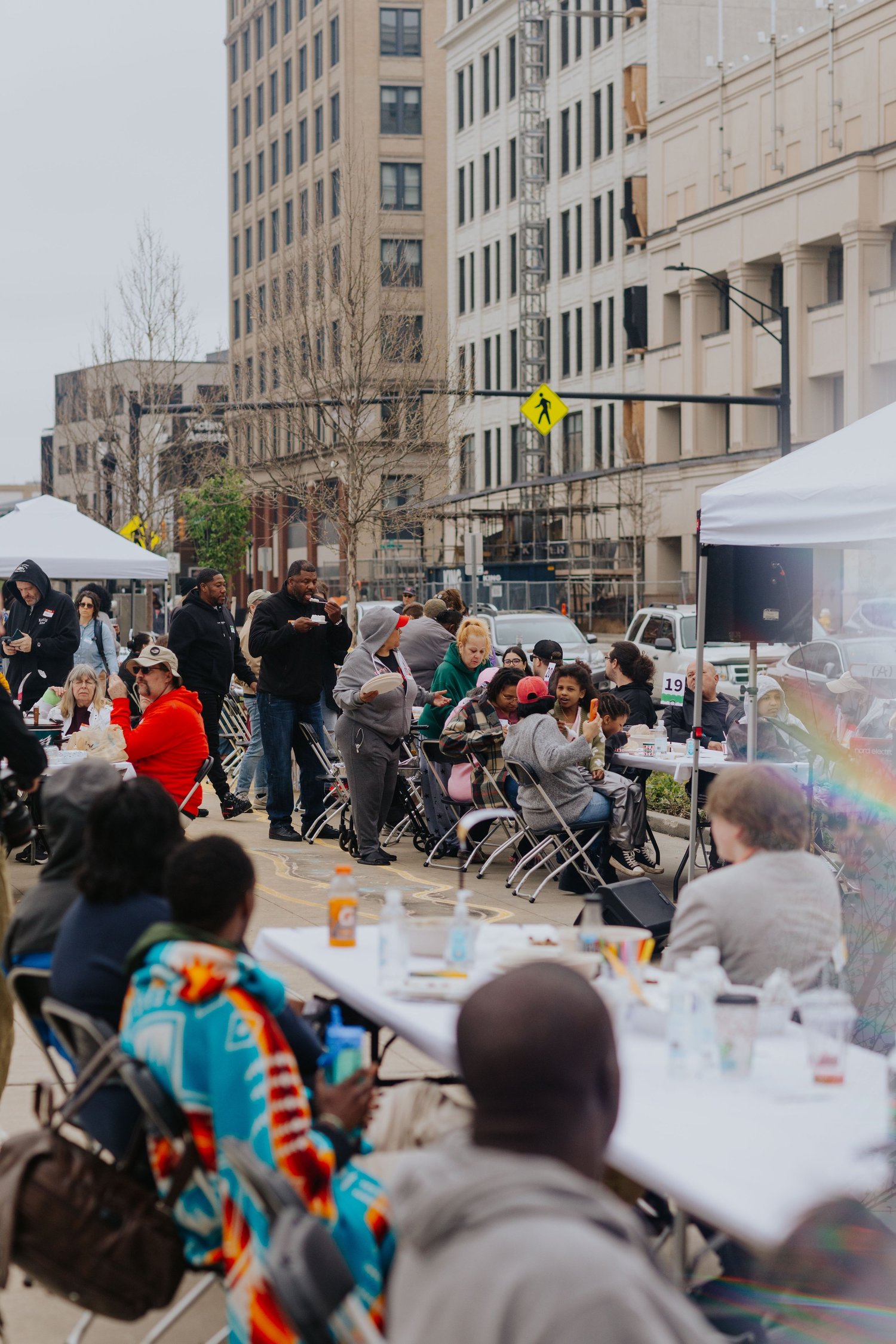 Community members gathered around tables on a downtown Akron street.