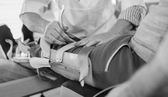 Clinician fitting a knee brace to a patient