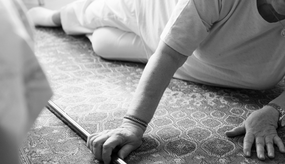 An older person on the floor after a fall, with a walking stick beside them