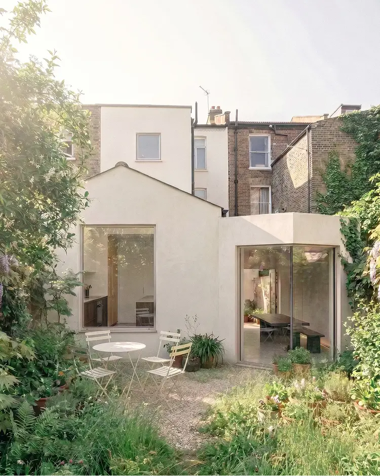 Visualisation of the proposed rear extension: a pitched gabled volume beside a lower flat-roofed one, both finished in sand-coloured lime render