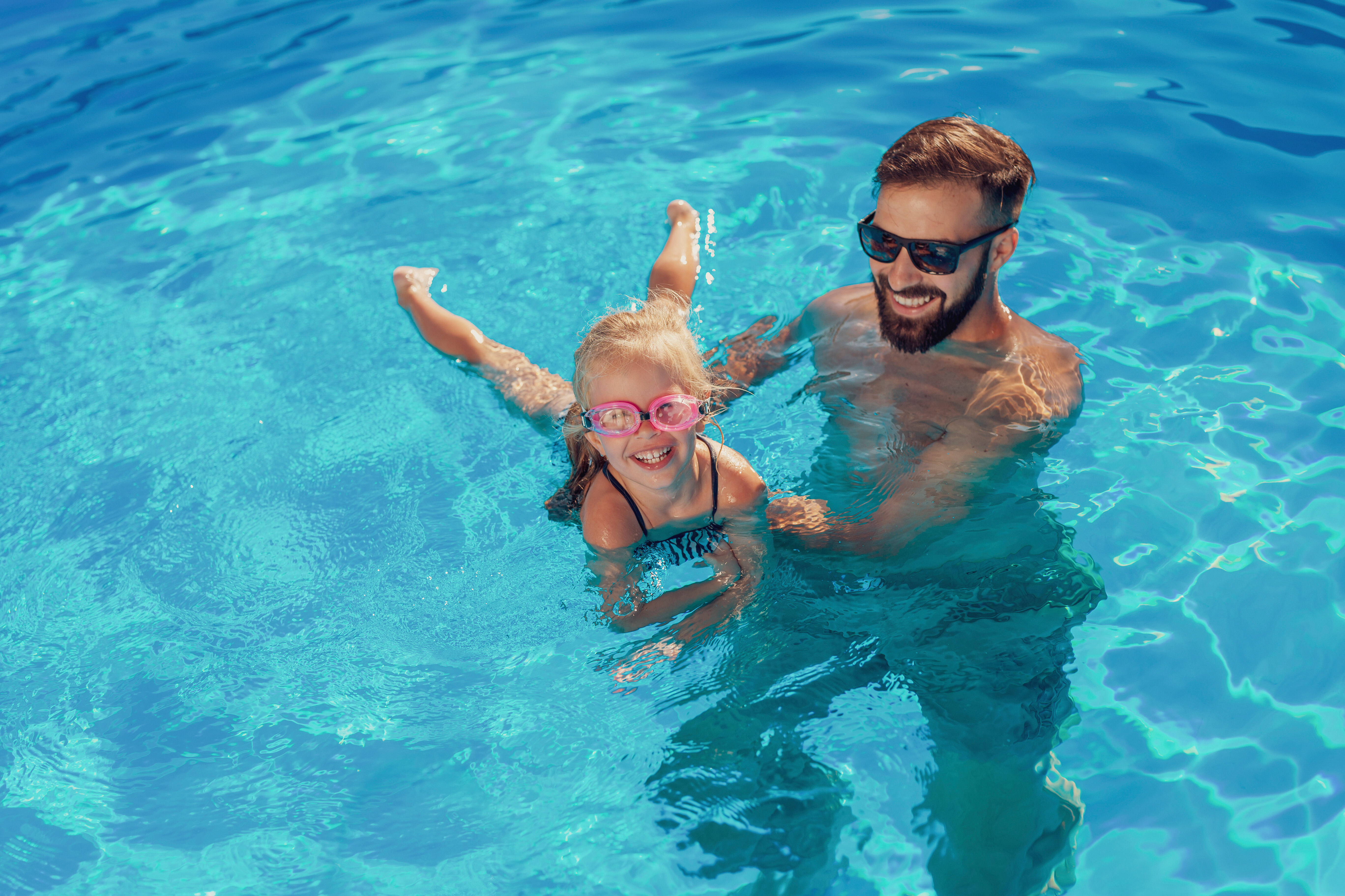 Man and child in pool stock image