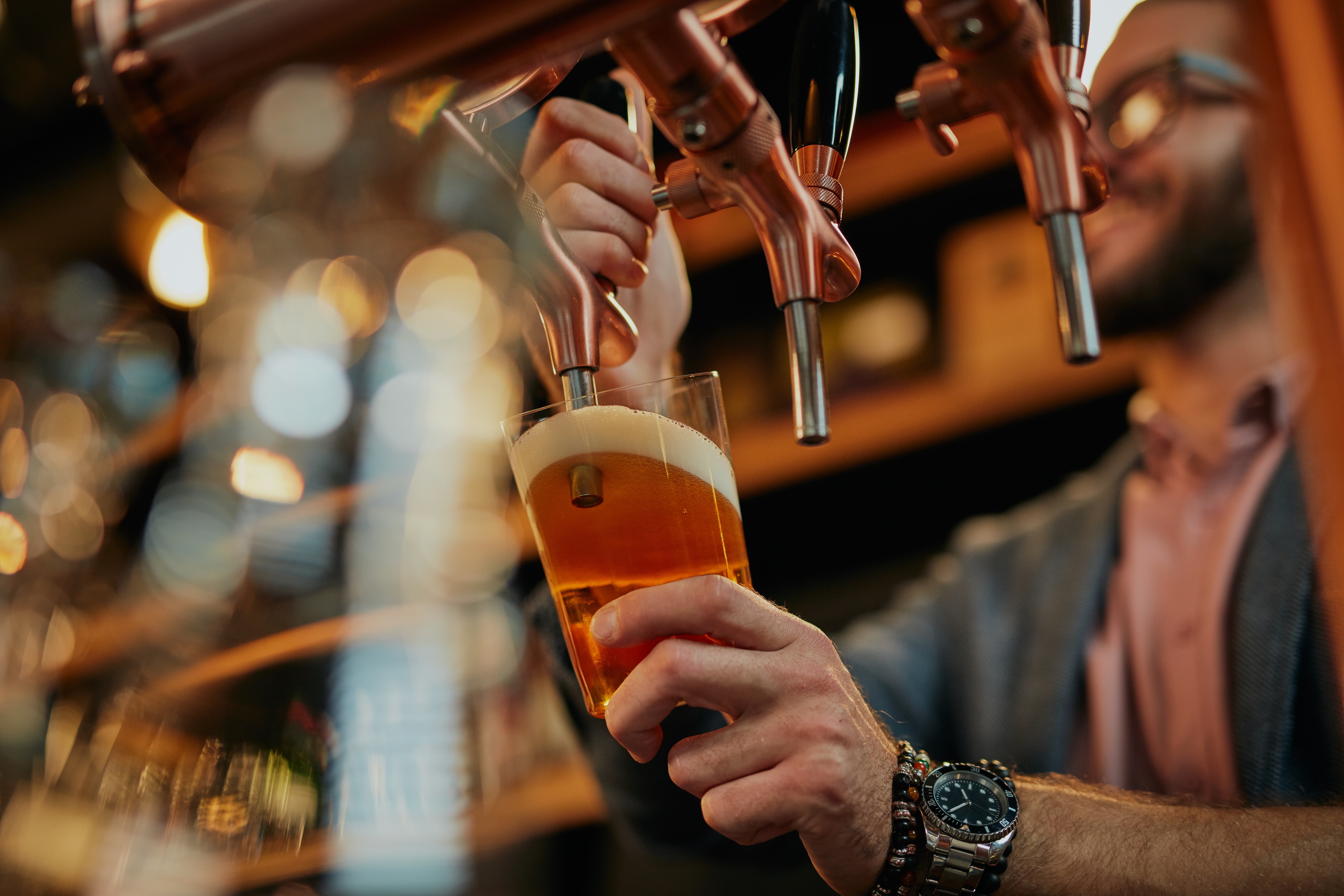 Man pouring a beer on tap stock image