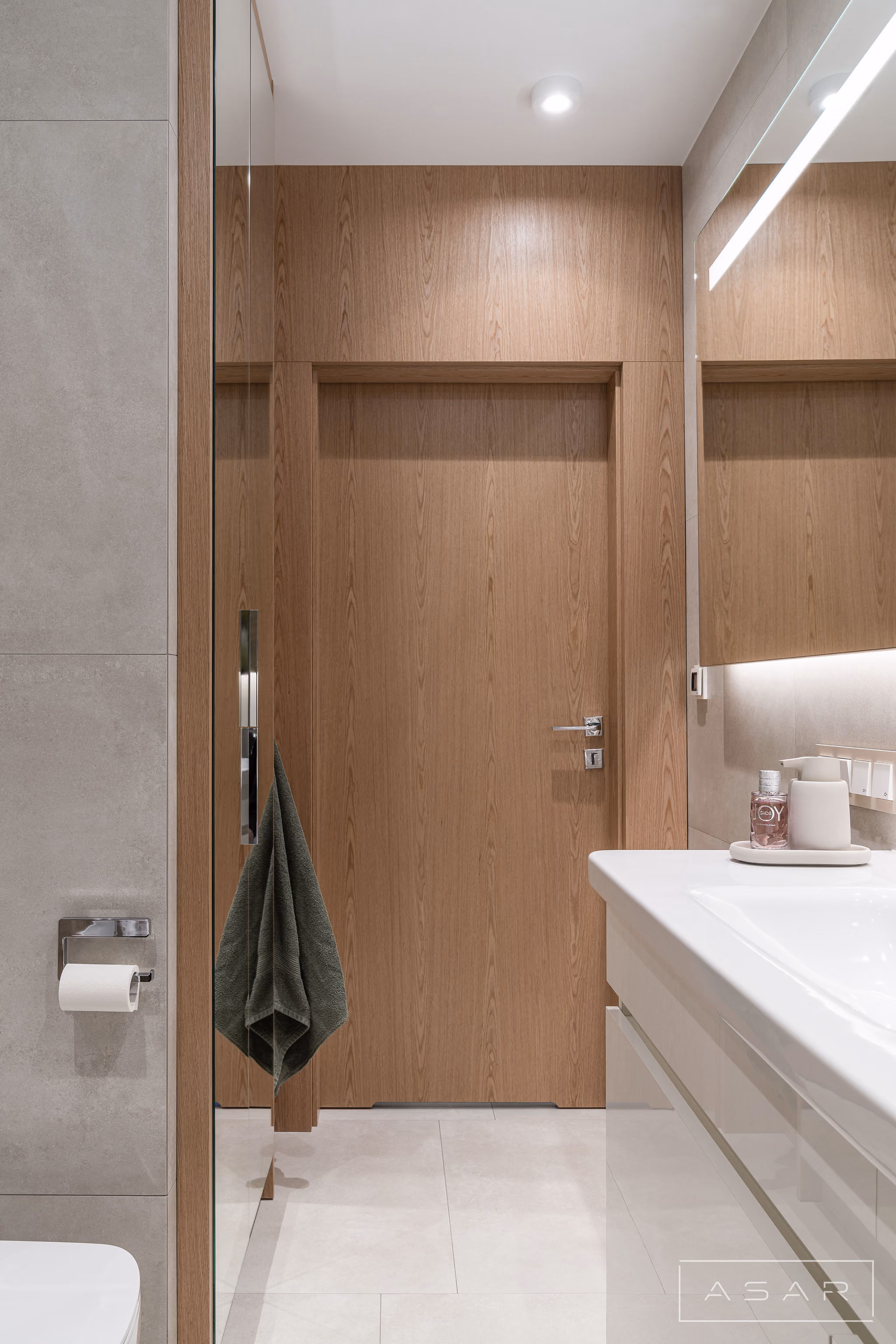 Jasna łazienka z drewnianymi drzwiami i zabudową w Apartamencie Oliwa – ASAR PROJEKT
