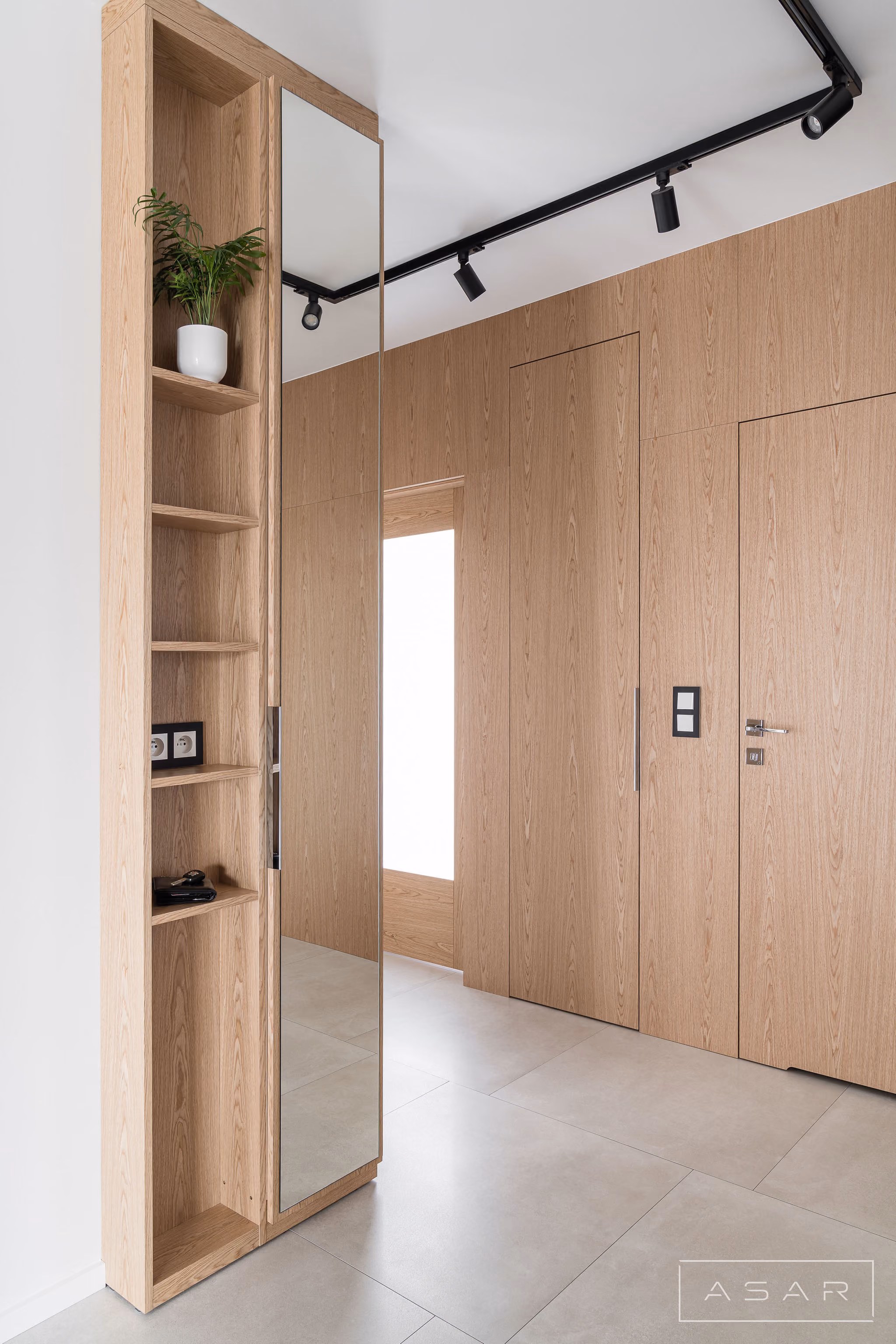 Zabudowa wejściowa z drewnianymi frontami i lustrem w Apartamencie Oliwa – ASAR PROJEKT