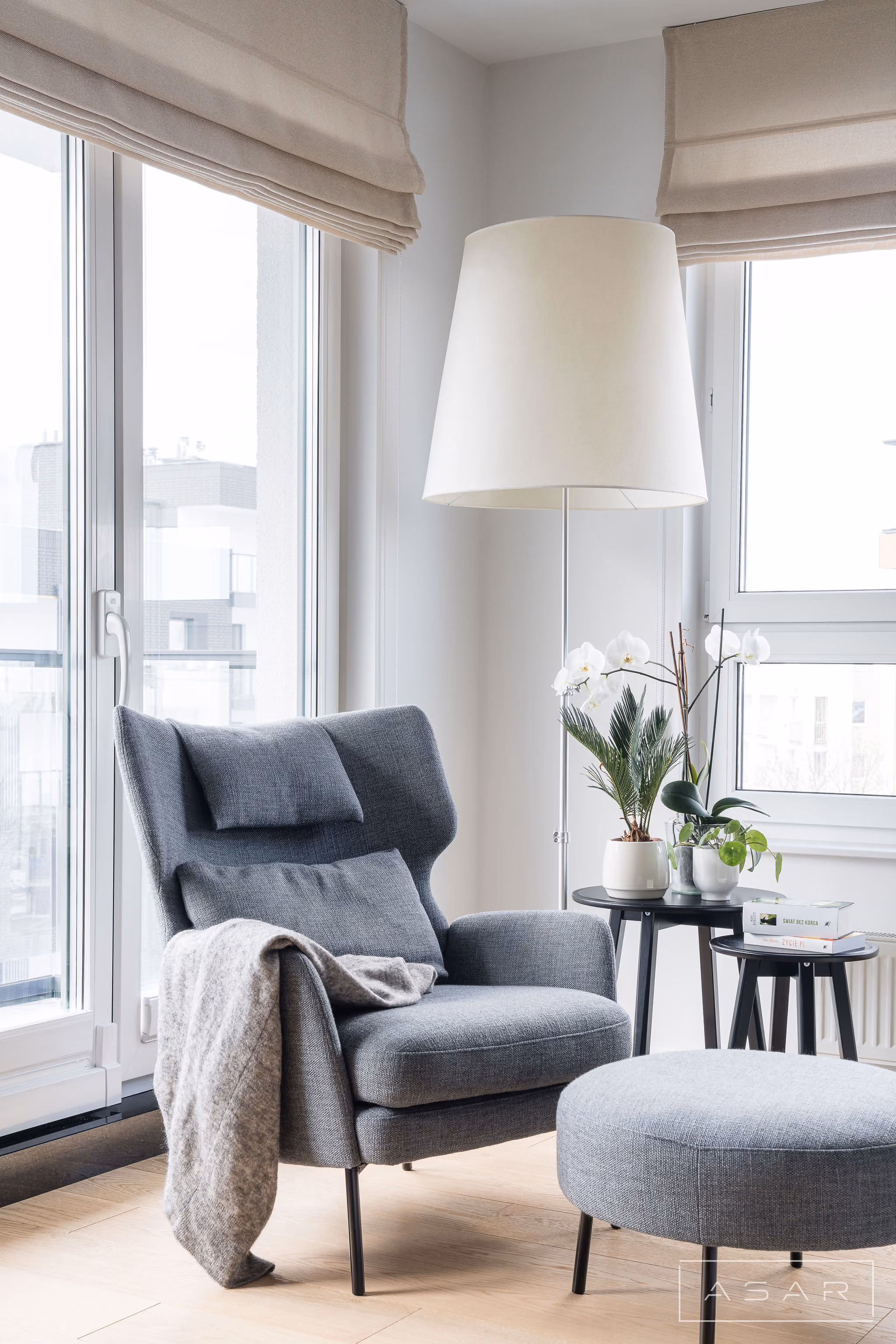 Jasne wnętrze salonu z fotelem, roślinami i drewnianą zabudową w Apartamencie Oliwa – ASAR PROJEKT